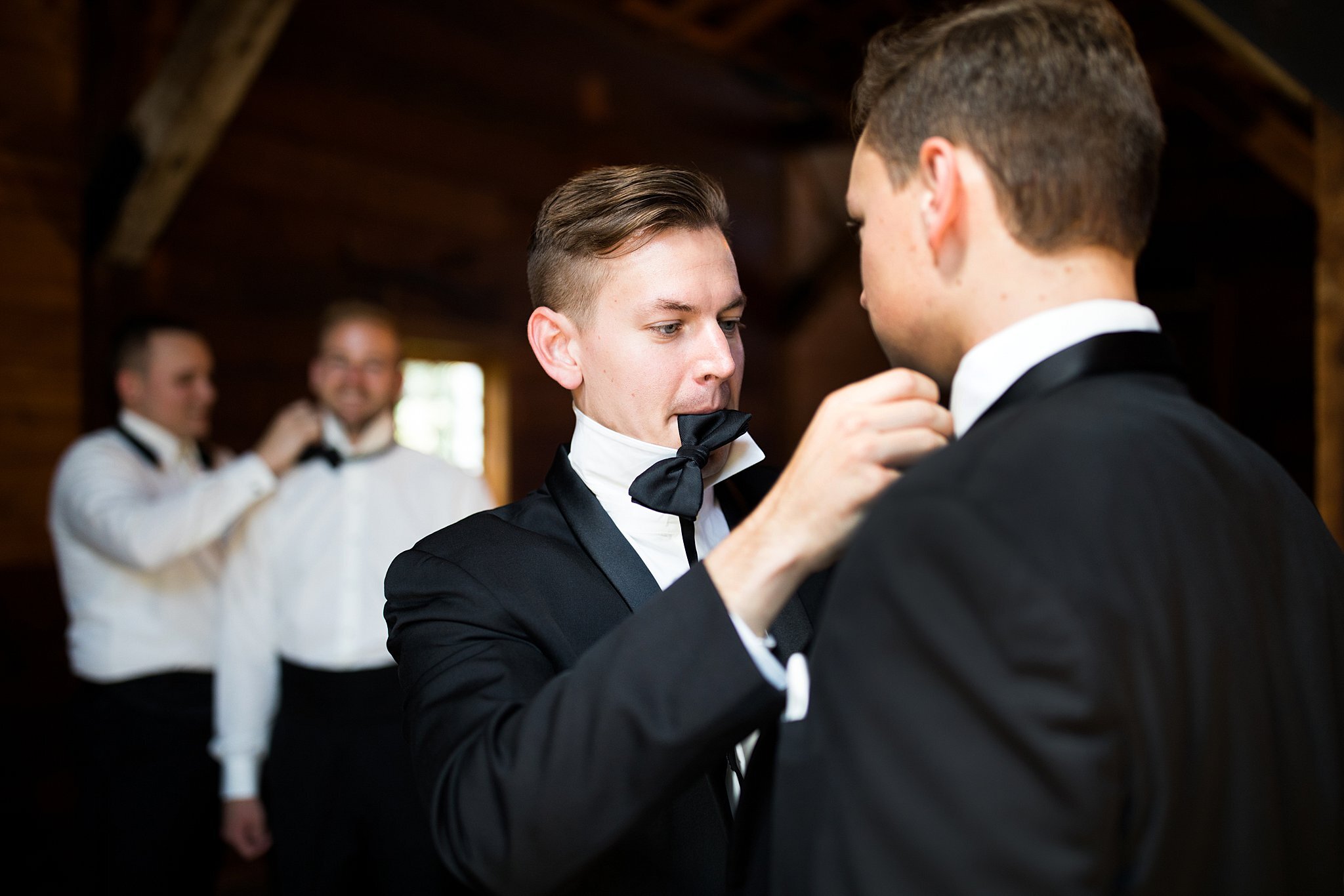  Groom adjusting groomsman's collar. 