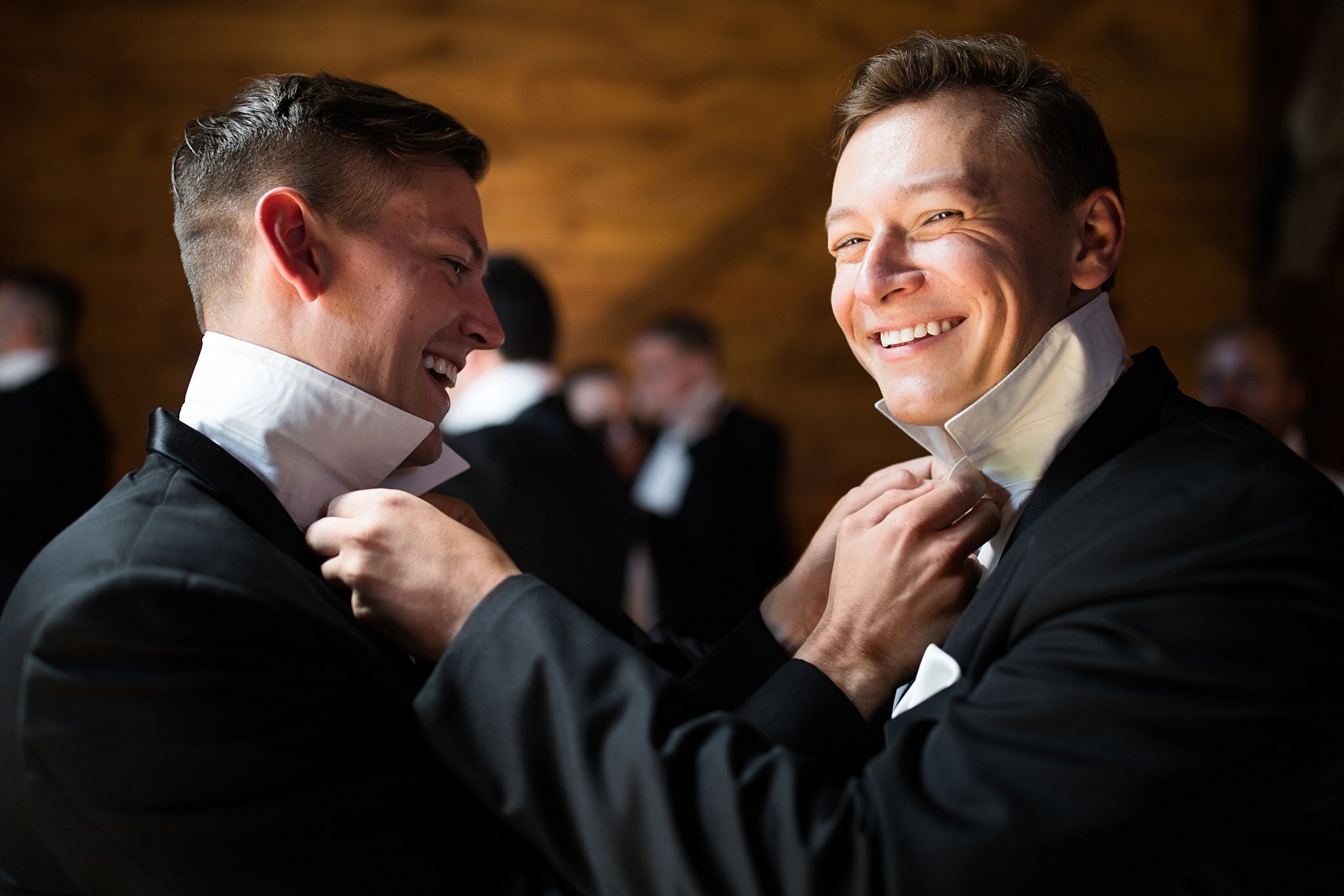  Groom and groomsman button up each other's shirt. 