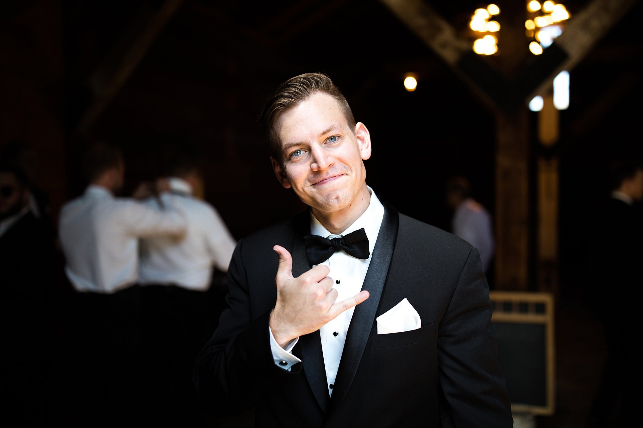  Groom smiling and signing hang loose. 