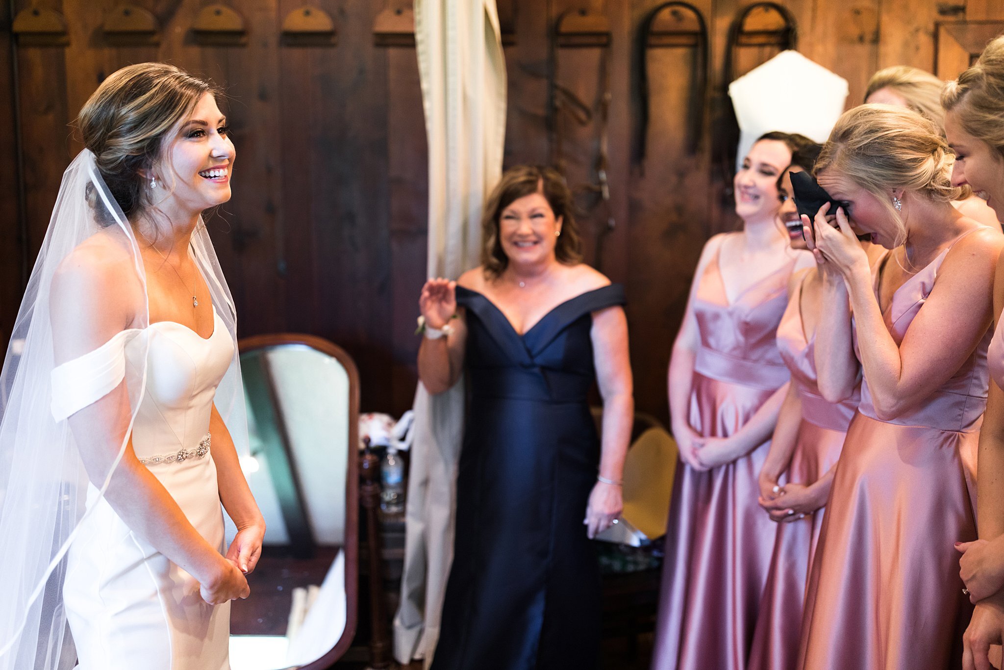  Bridesmaids and mother laughing during bride's first look. 