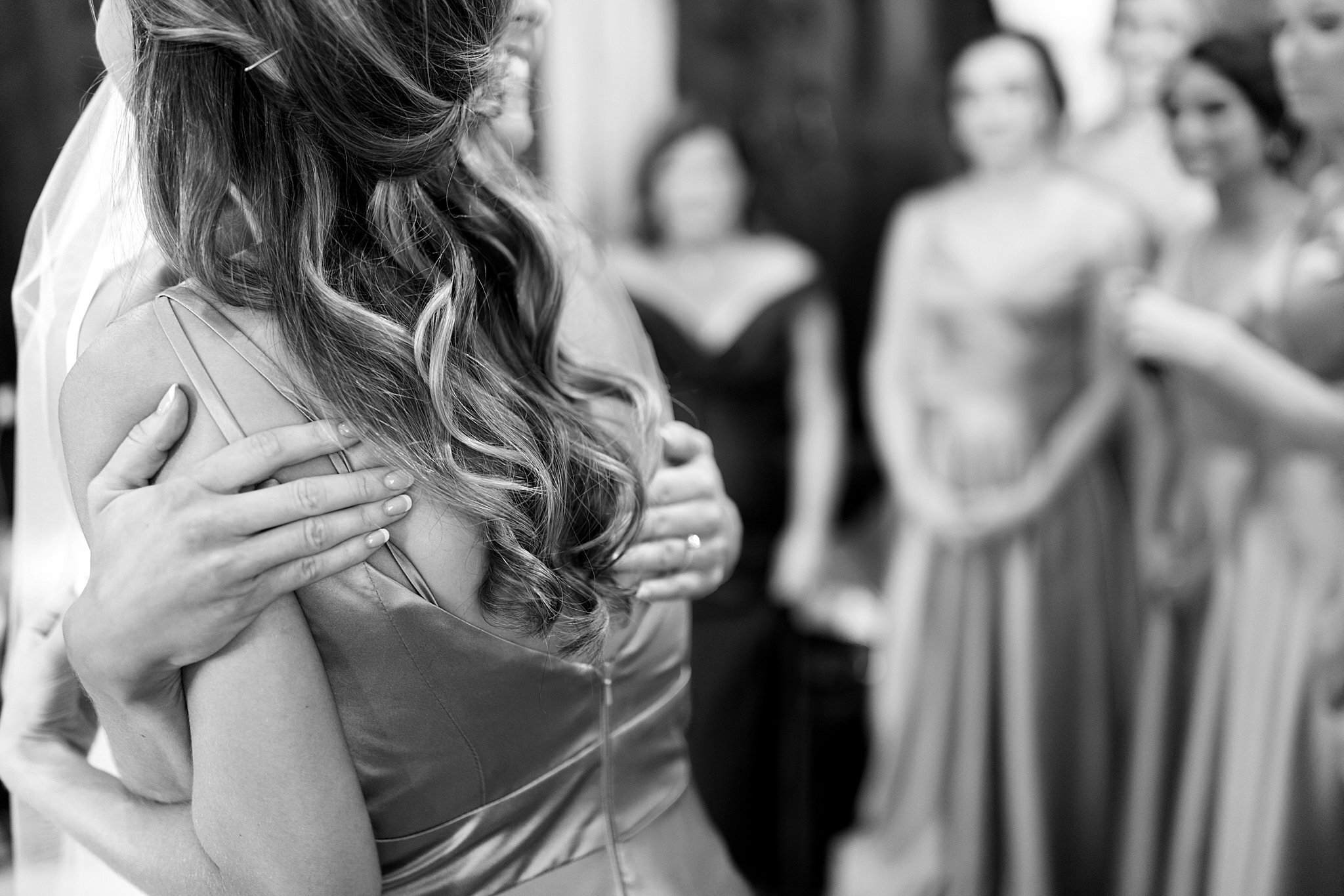  Bridesmaid giving bride a hug. 