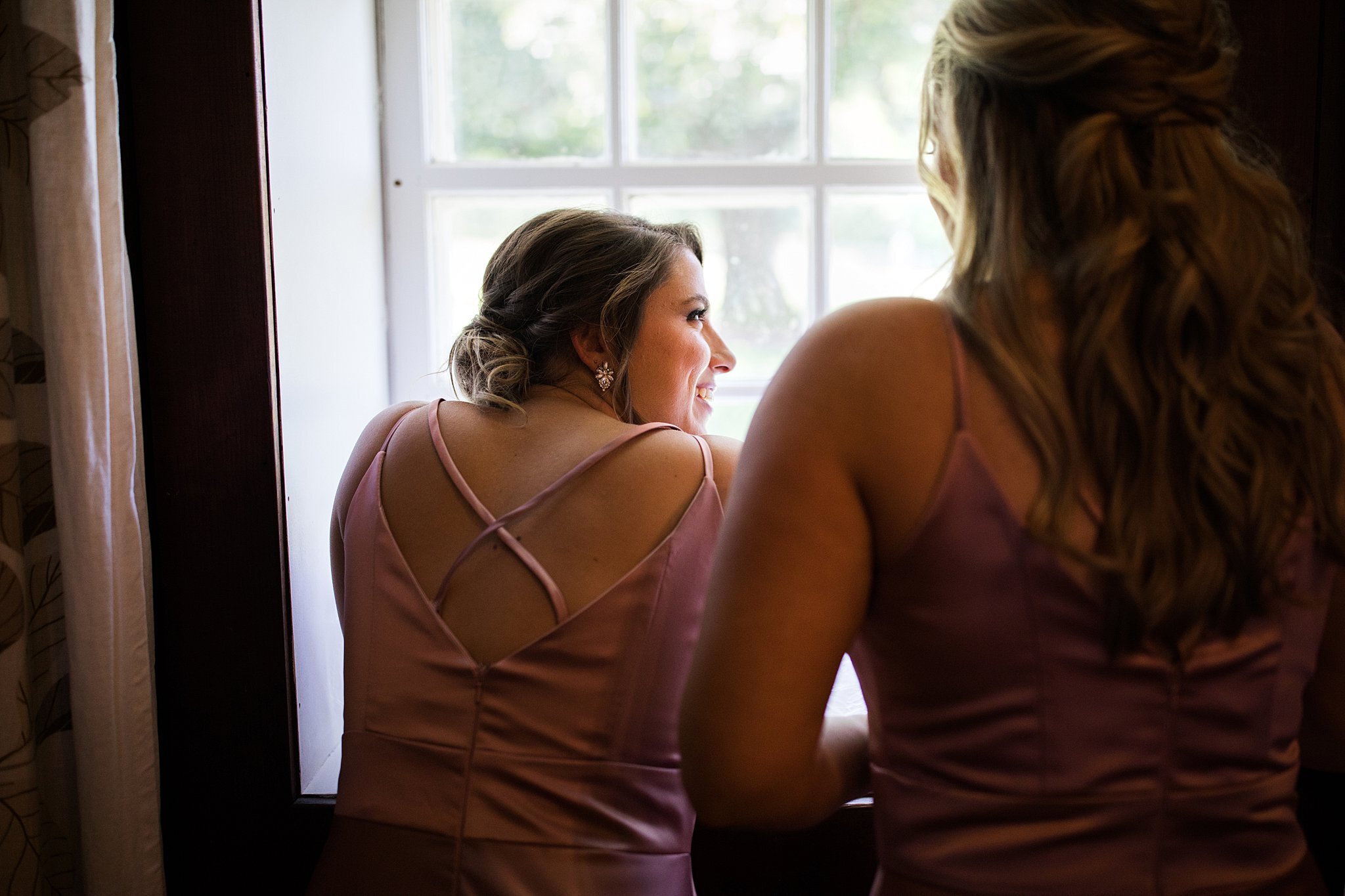  Bridesmaids watching bride and groom's first look outside window. 