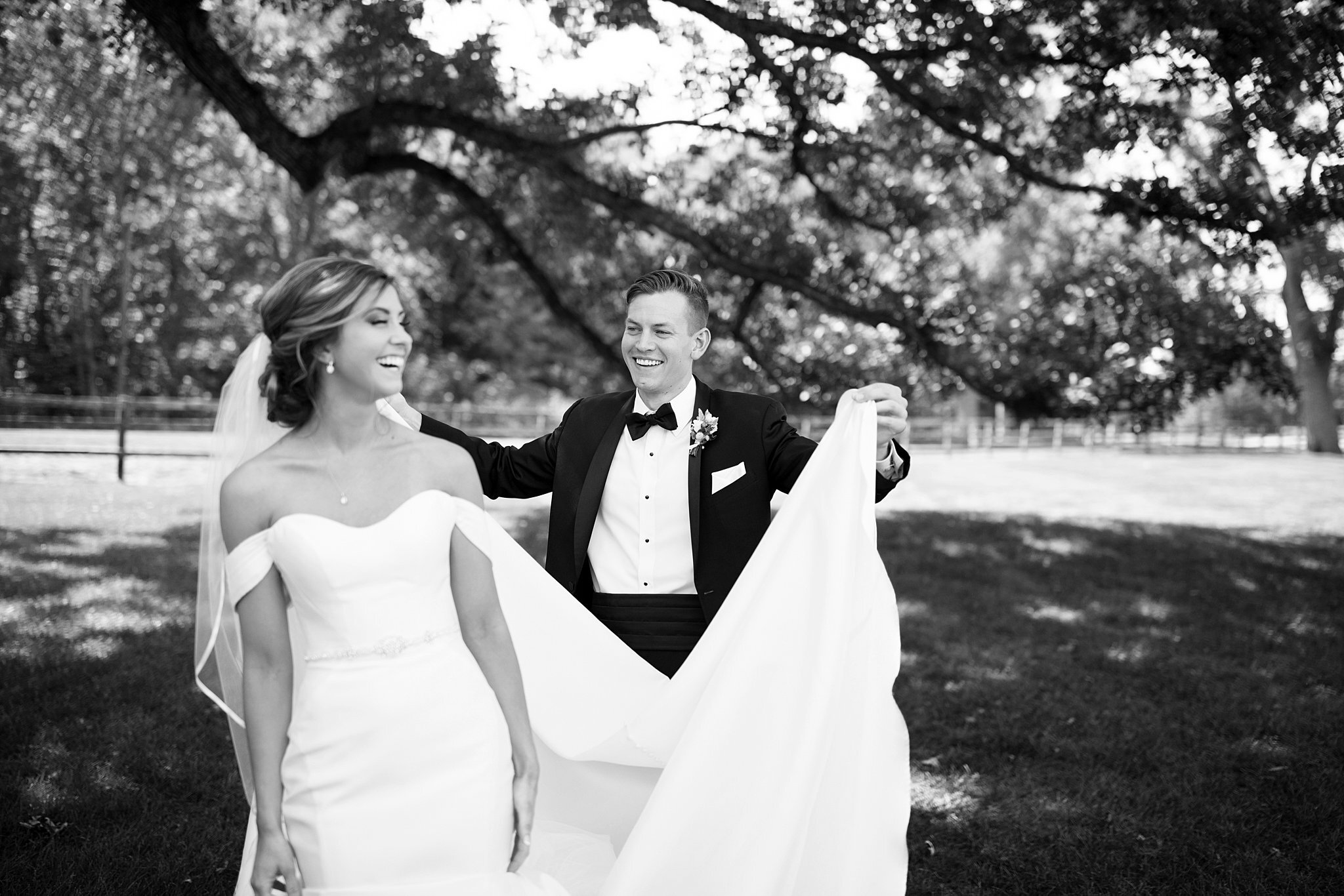  Groom carrying bride's wedding dress train. 