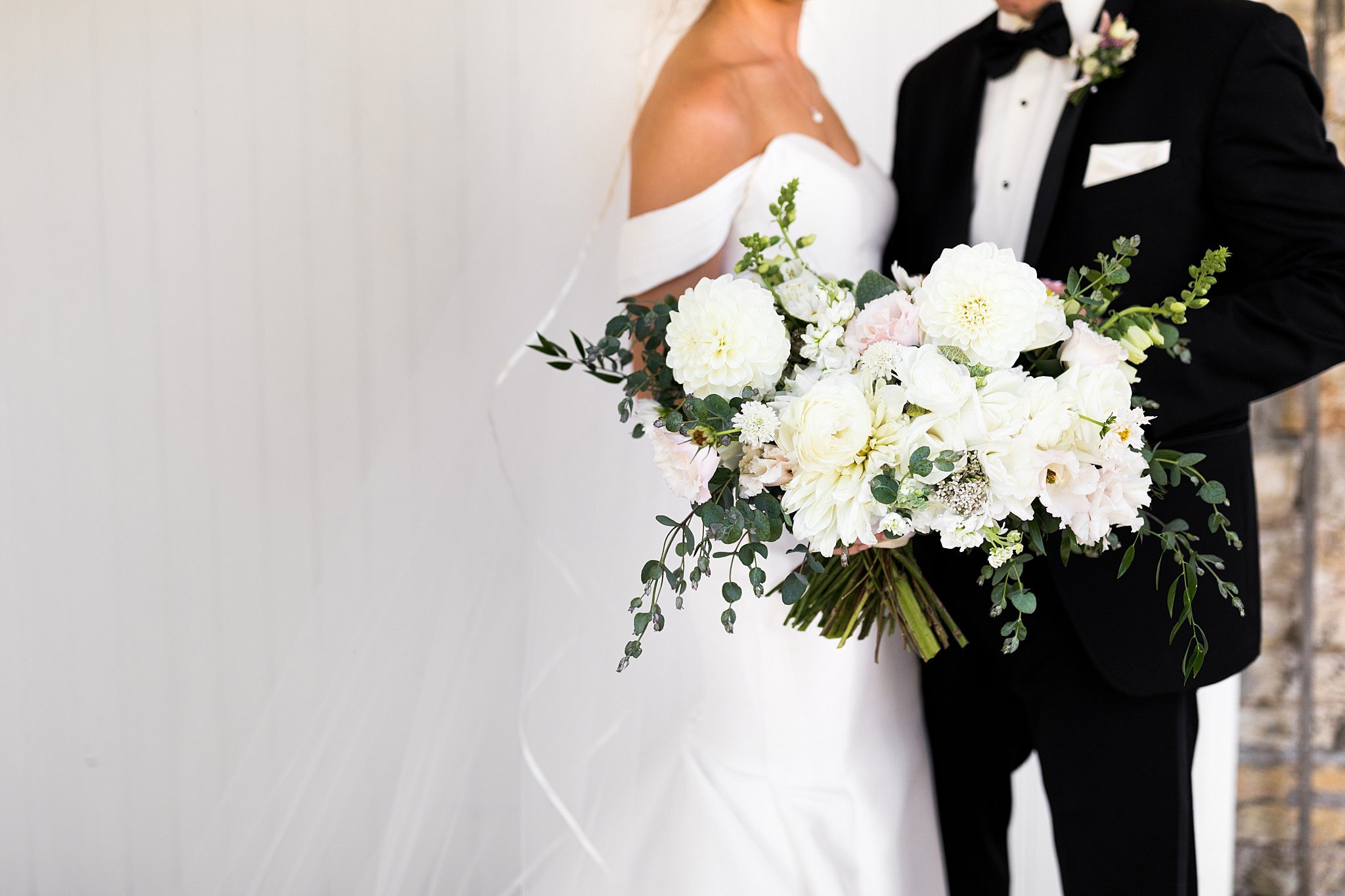  Bride and groom displaying bridal bouquet from Fox and Fern. 