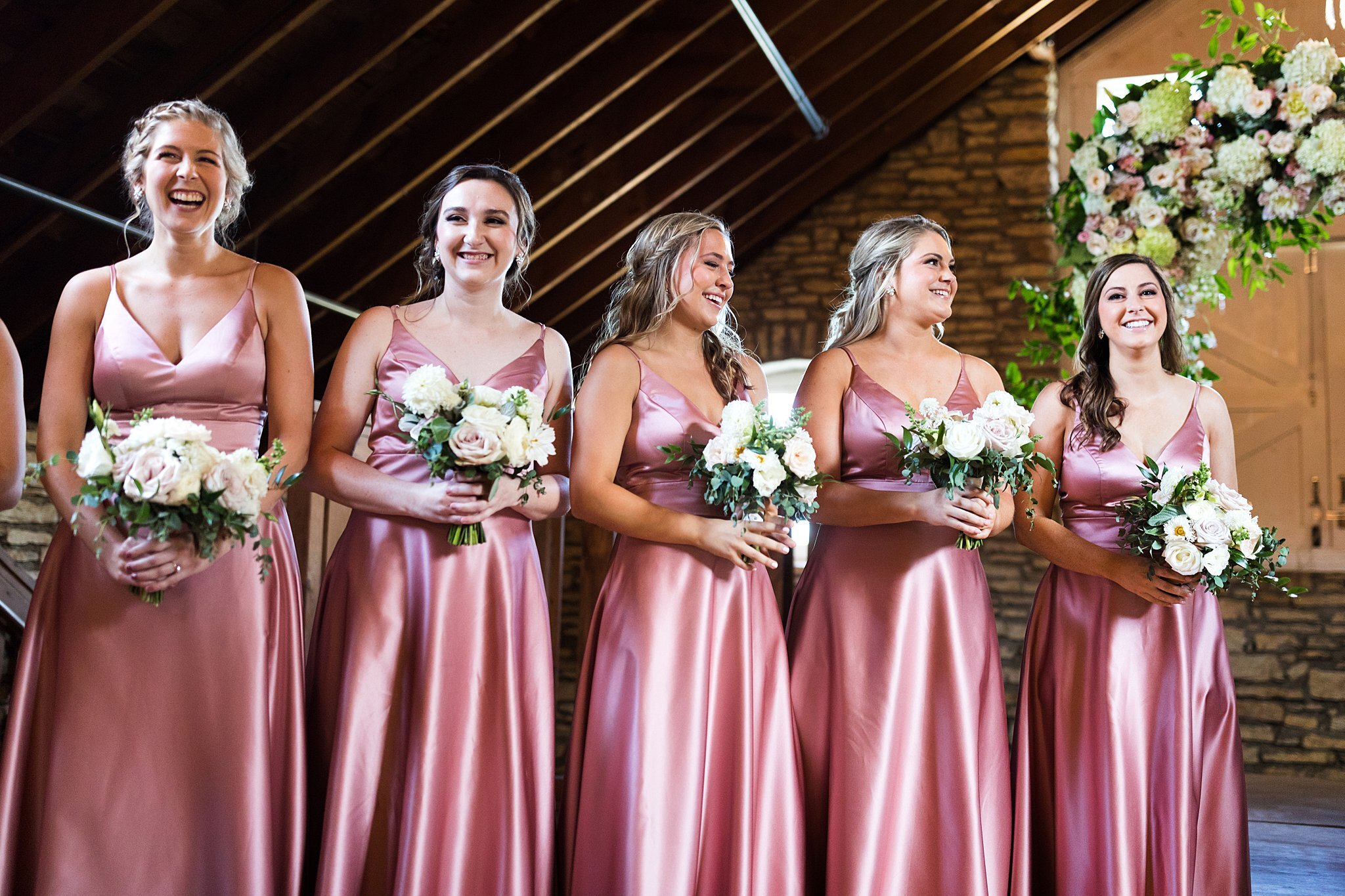  Bridesmaids holding bridal bouquets during ceremony. 