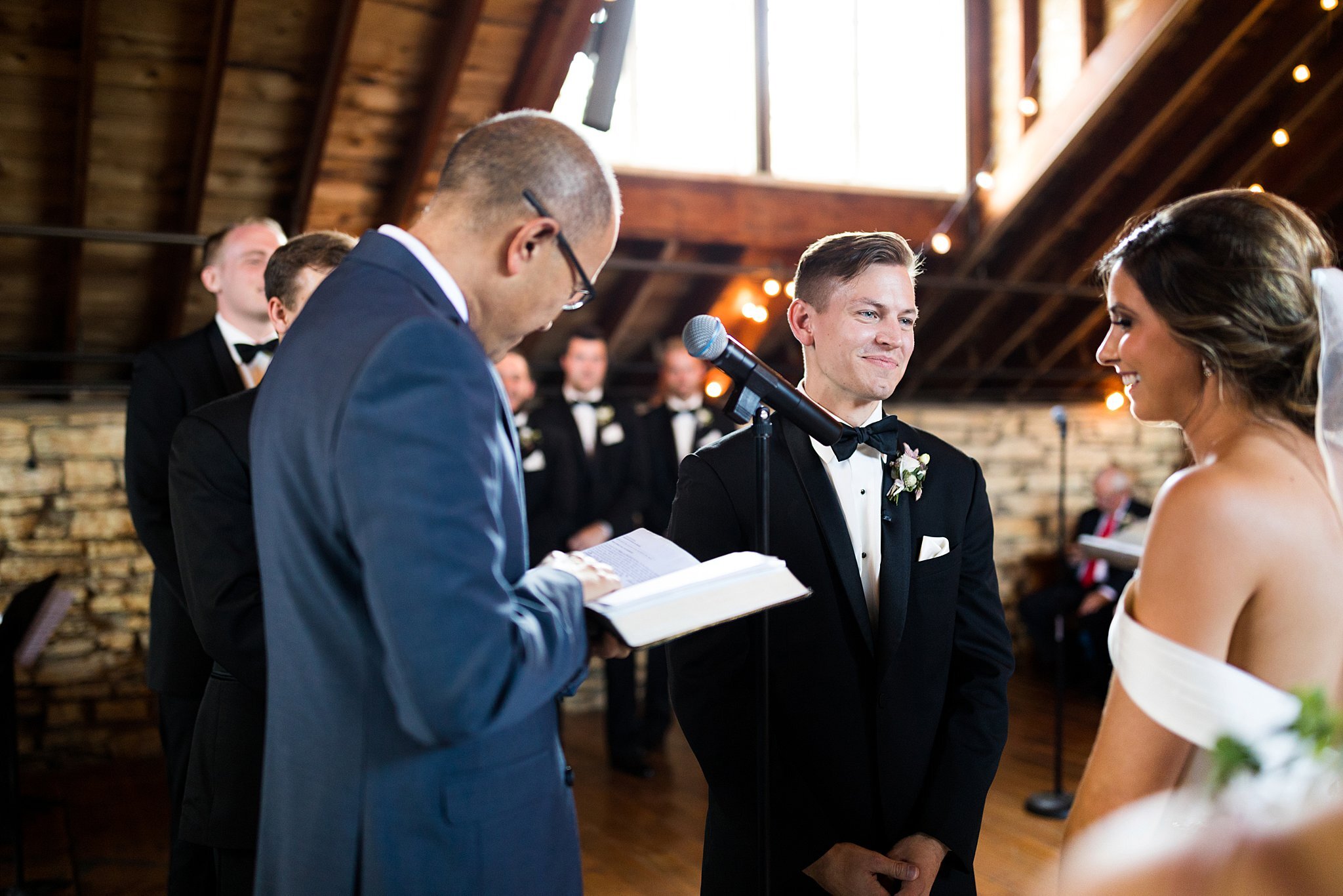  Officiant reading to bride and groom during ceremony. 