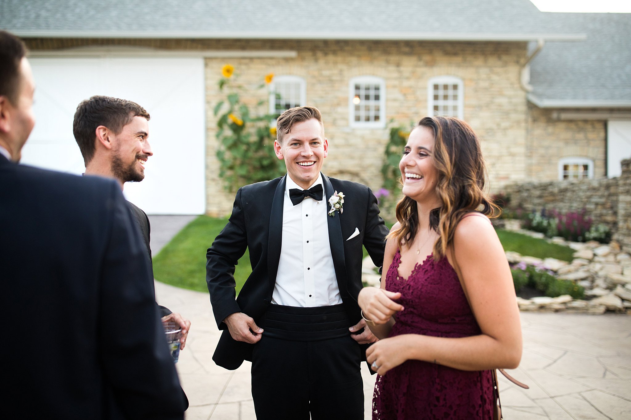  Groom mingling with guests after sunset at Mayowood Stone Barn. 