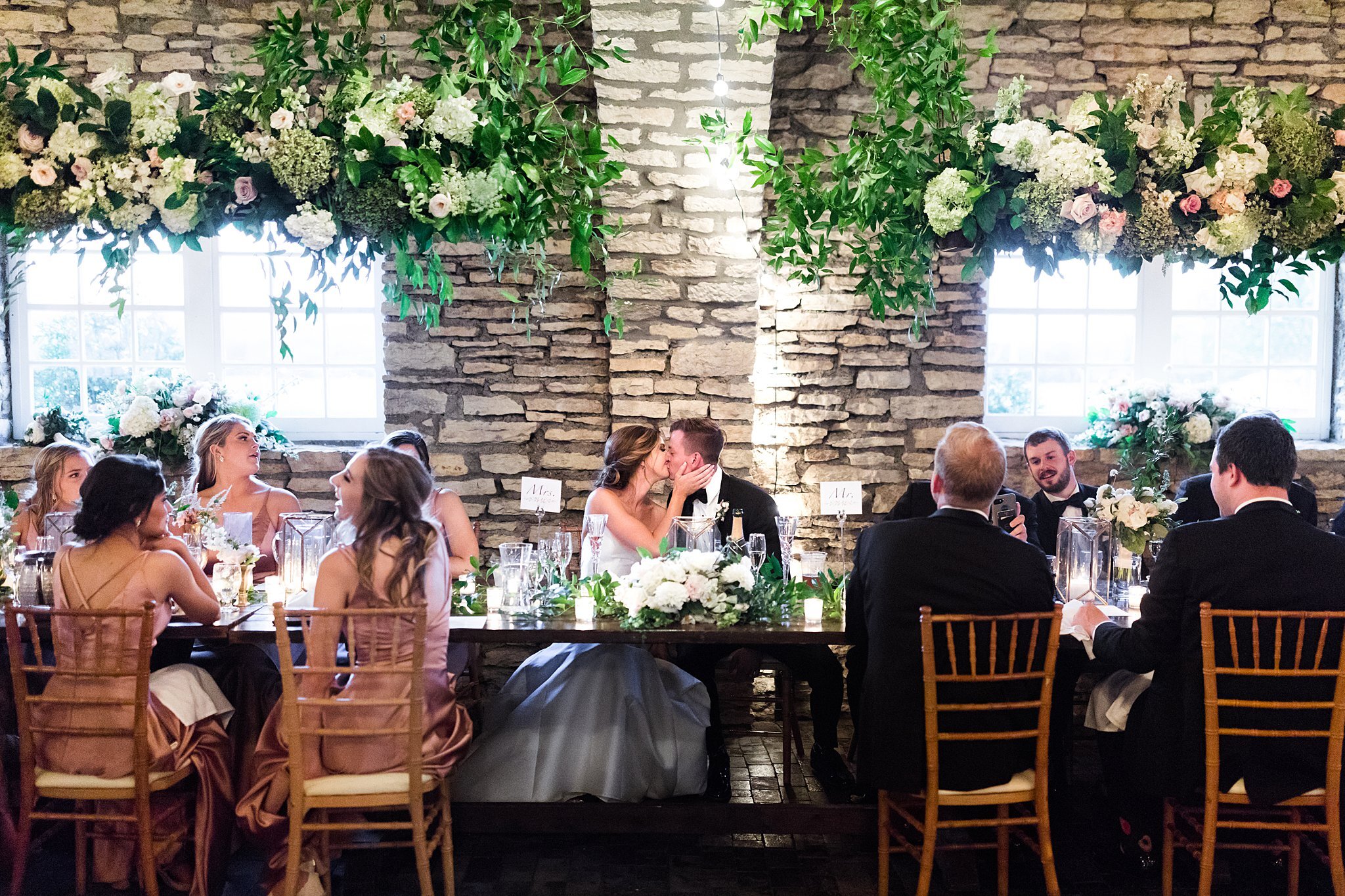  Bride and groom share a kiss at the head table during reception. 