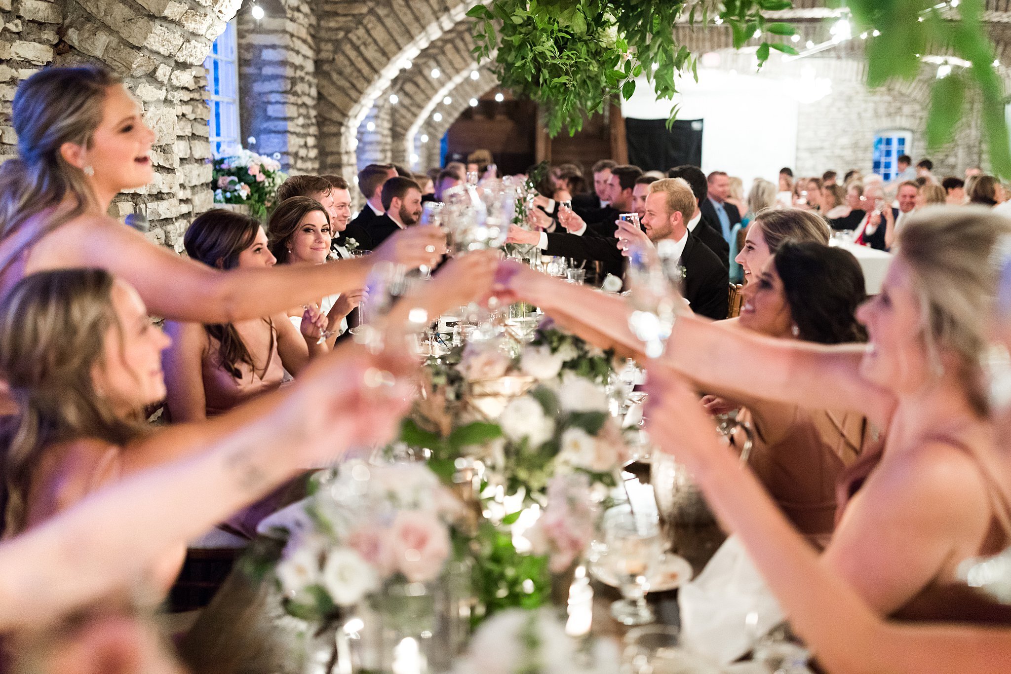  Wedding party cheers champagne glasses at head table 2 of 2. 