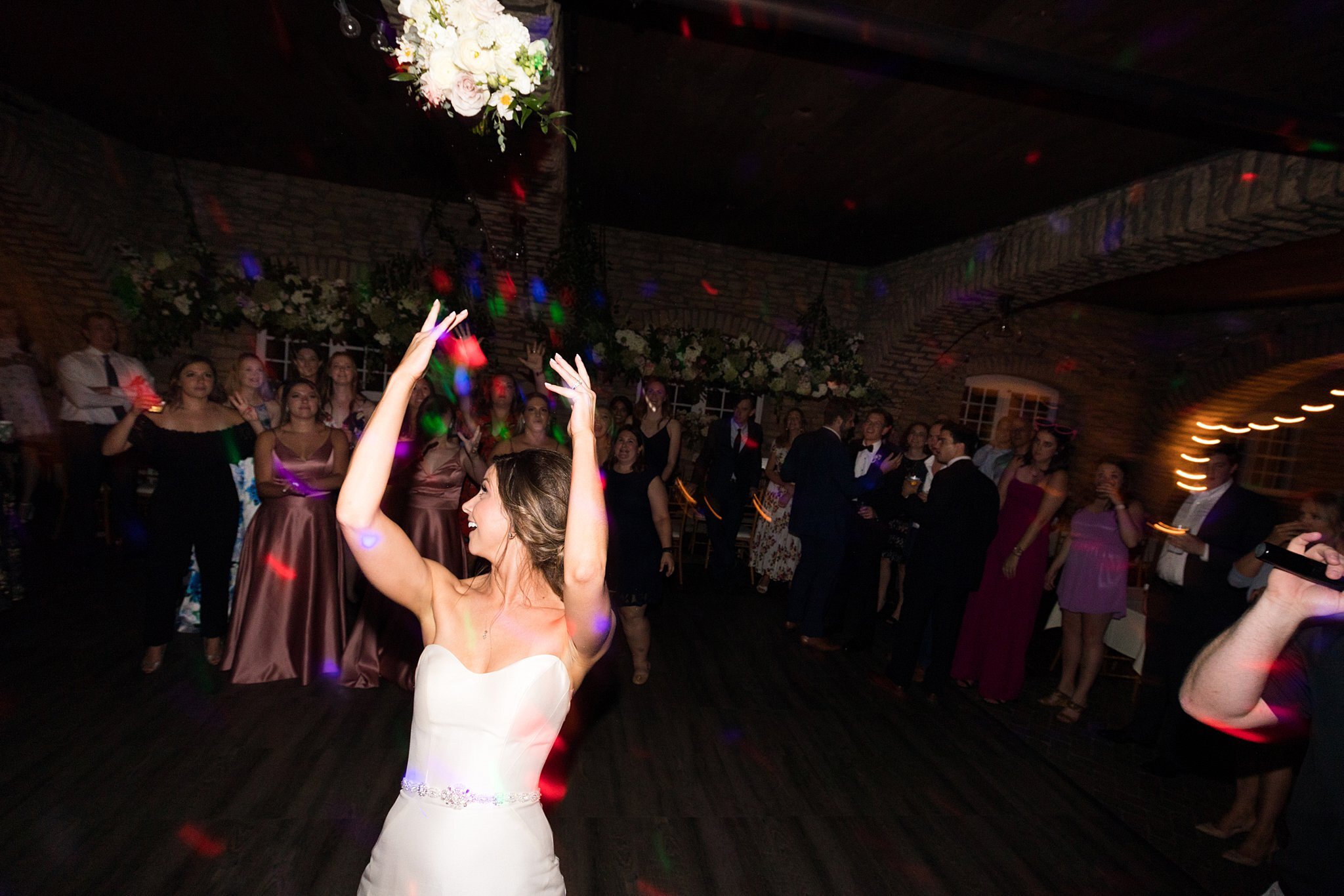  Bride tosses bouquet on the dance floor. 