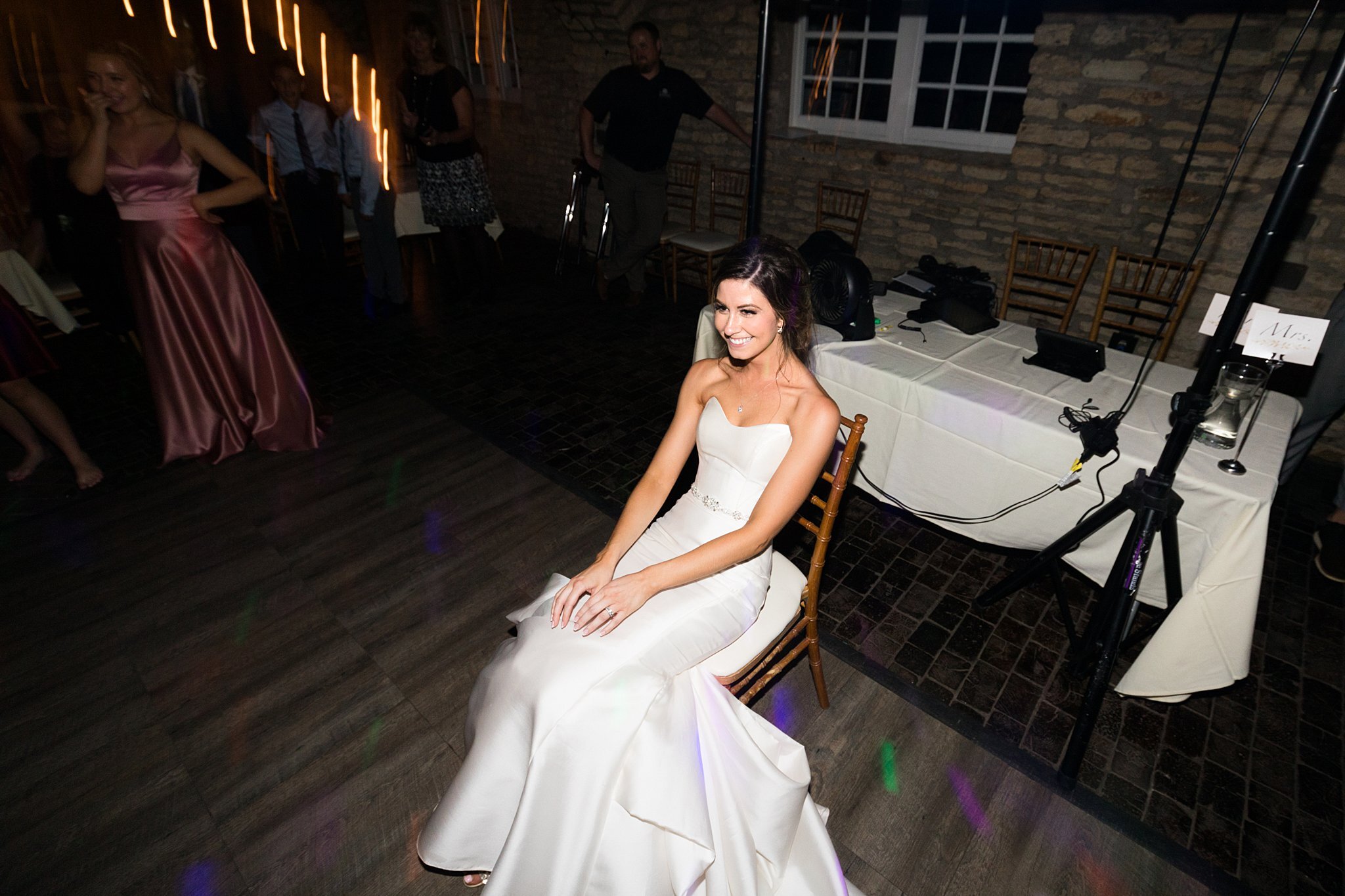  Bride sitting on chair on the dance floor at Mayowood Stone Barn. 