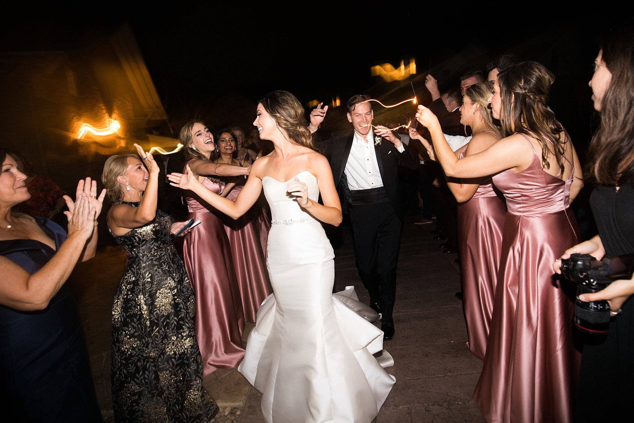  Bride and groom high-fiving guests while leaving Mayowood Stone Barn. 