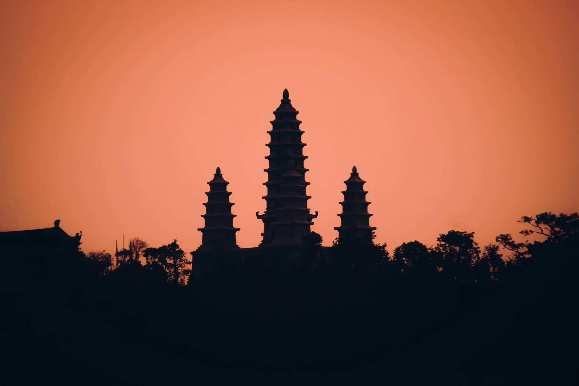 Silhouette of a buddhist temple amongst a  red morning sunrise, Hon Gai, Vietnam
