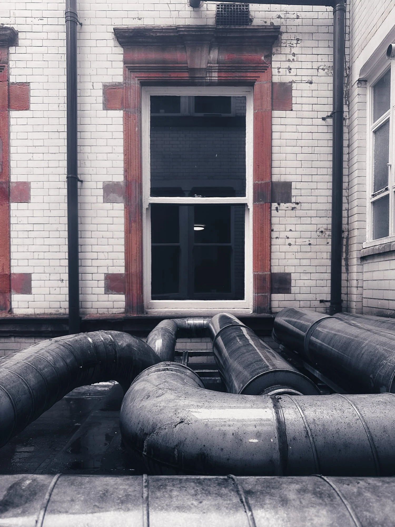 Window frame with pipes running along the roof, Liverpool, England