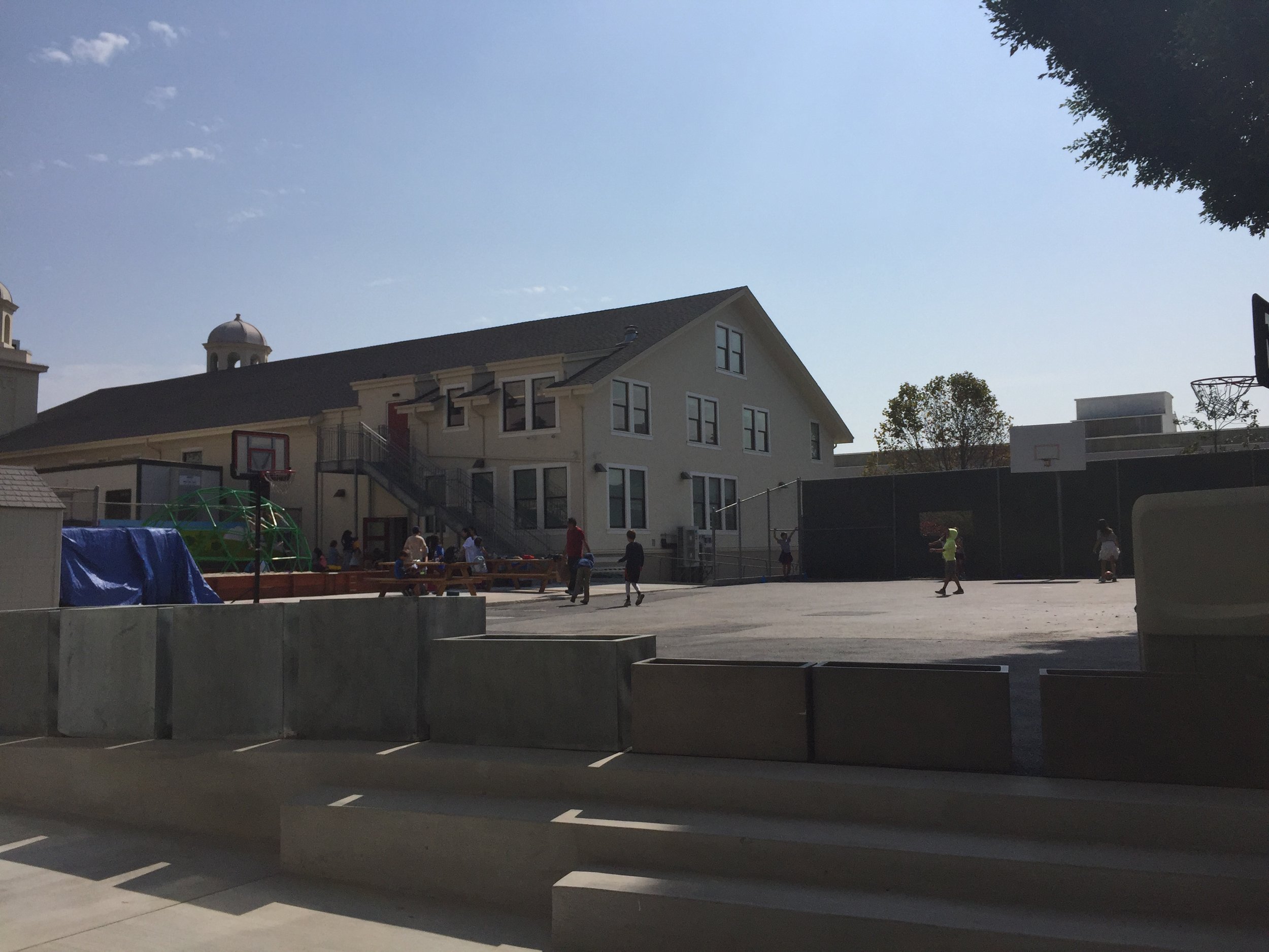 The elementary playground space between the Rectory and Pioneer Hall. Greenery has been planted along each walkway.