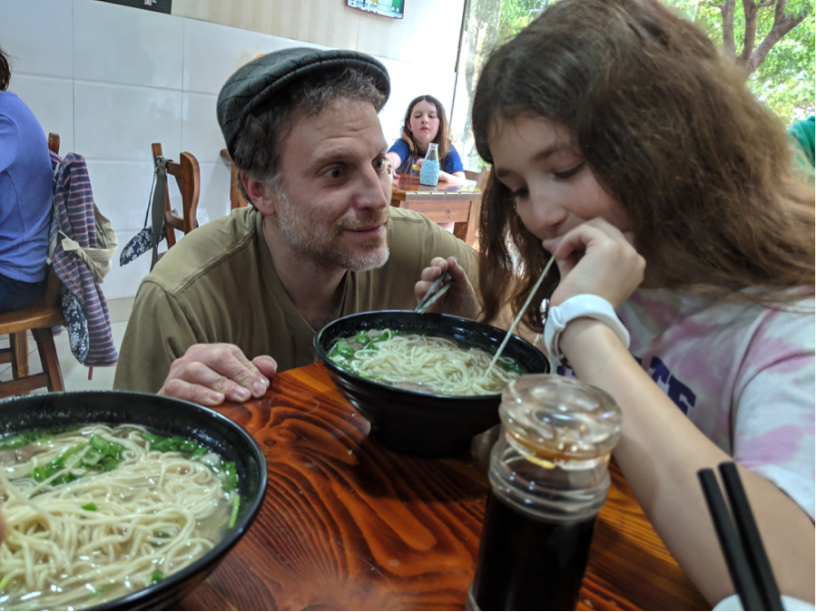 Mike watches a student enjoy her noodles. His obsession with Lanzhou Lamian is legendary.