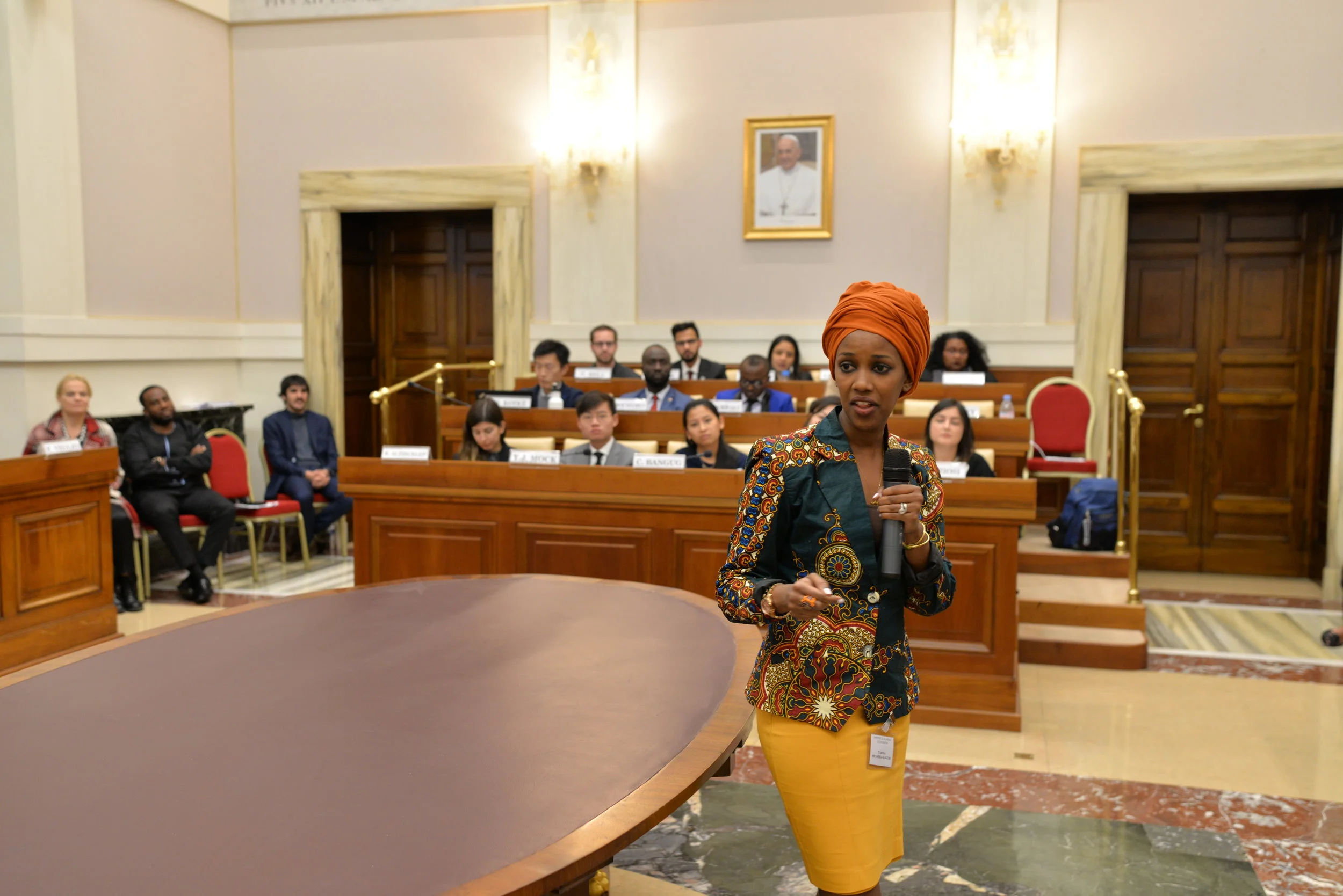Tabitha Mpamira-Kaguri walks around the convening hall as she tells her story with the EDJA Foundation. Photo Credits: Gabriella Marino/PAS