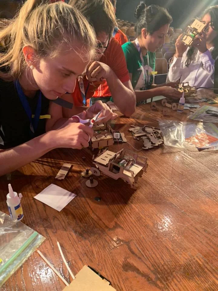 Workshop participants build their mini-cars while learning about renewable energy.