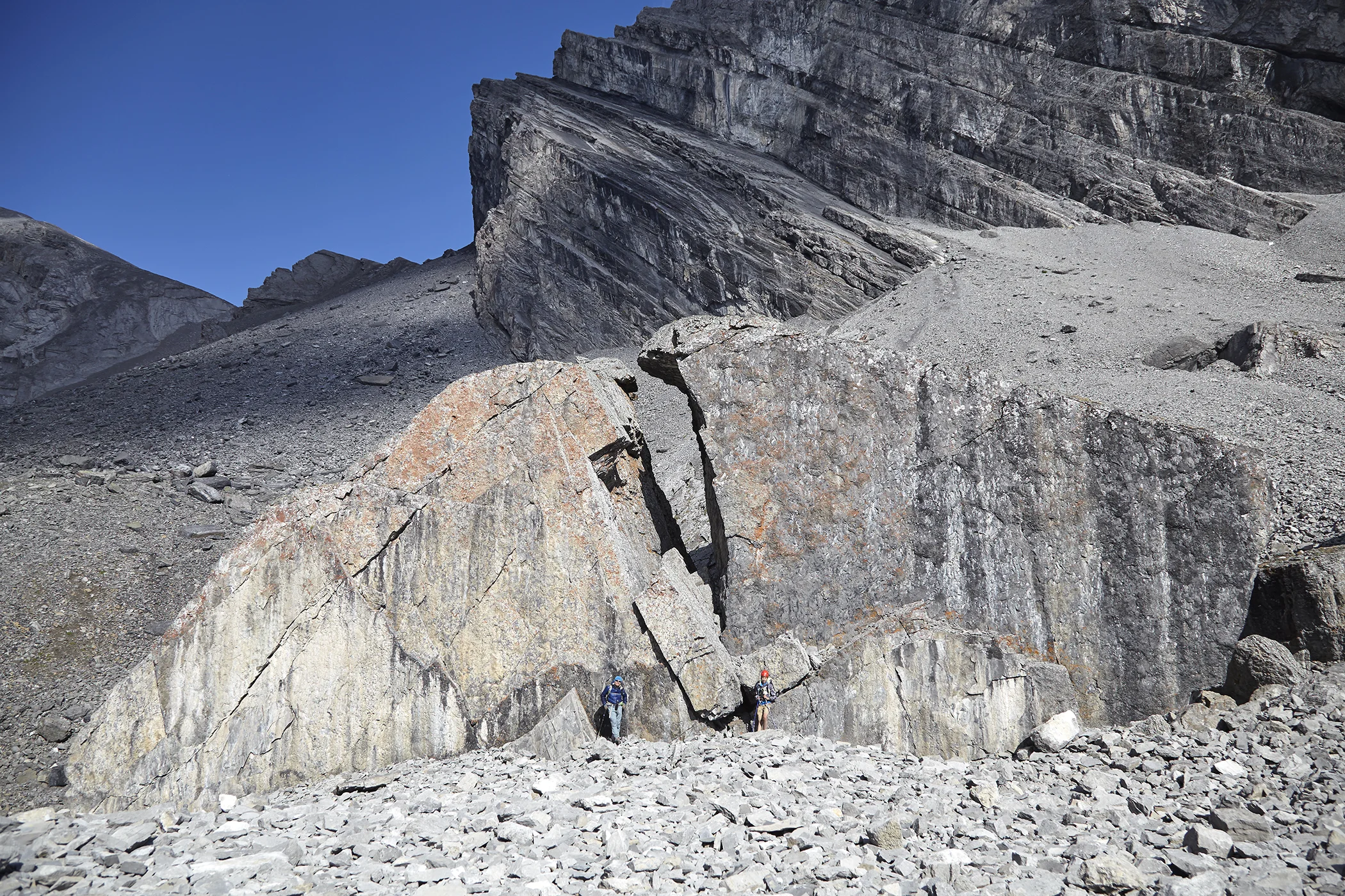 Milan and Yuri pose beneath a large boulder on descent.