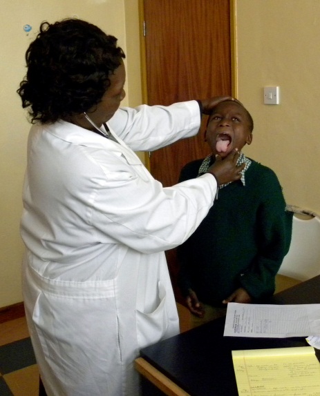  A doctor gives a child his annual checkup at the Sugarbaker Memorial Clinic. 