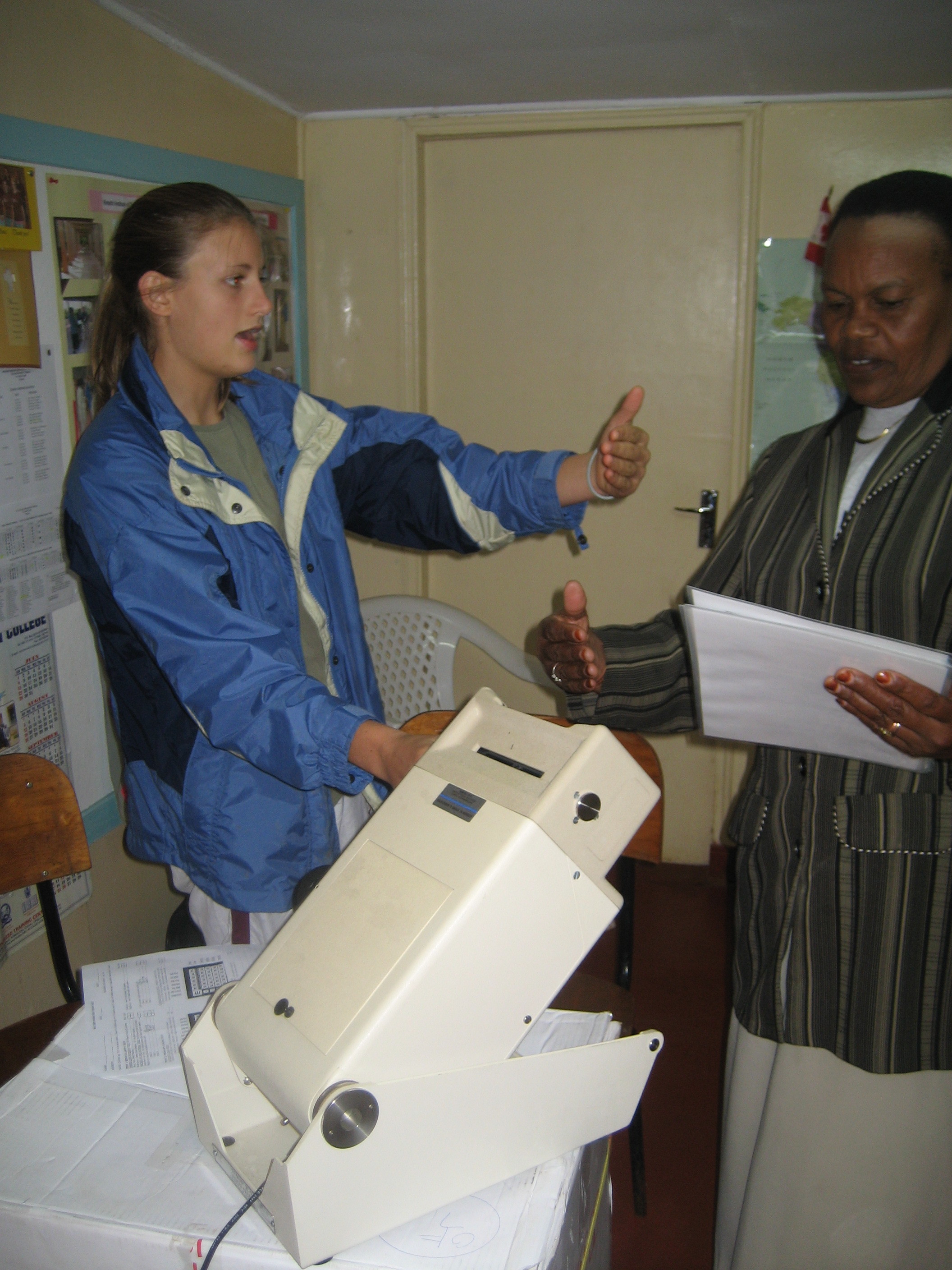  Hannah helps a nurse learn how to work the new vision testing machine at the Sugarbaker Memorial Clinic. 