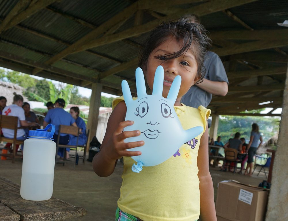  A glove balloon is sometimes the best toy to calm a child during their exam. This child shows off her balloon afterwards. 