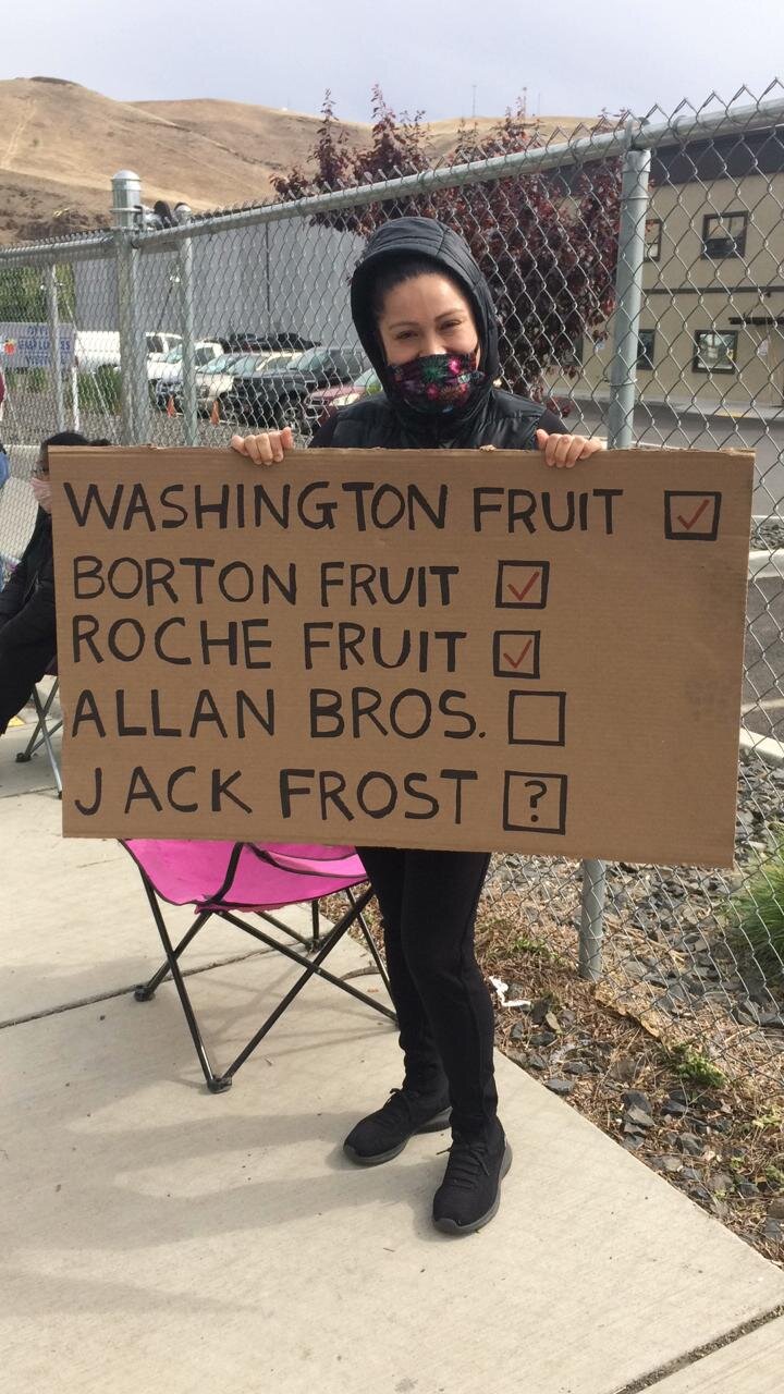  Second day of the strike at Jack Frost. A worker holds a sign showing the local packing sheds where workers already fought for and won hazard pay from their employers.   Photo by Maureen Darras  