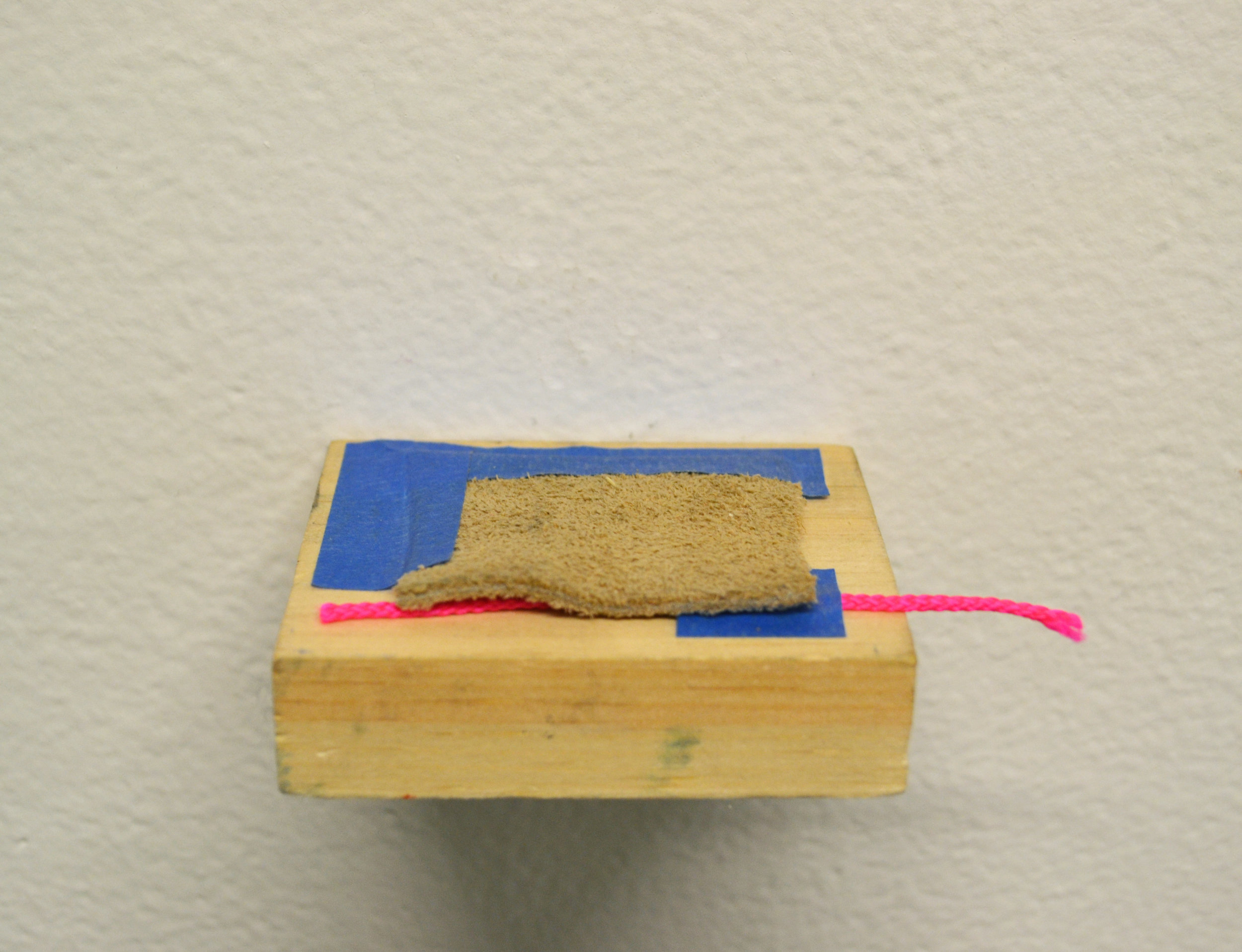  Painter's tape, suede, and plastic cord on wood 