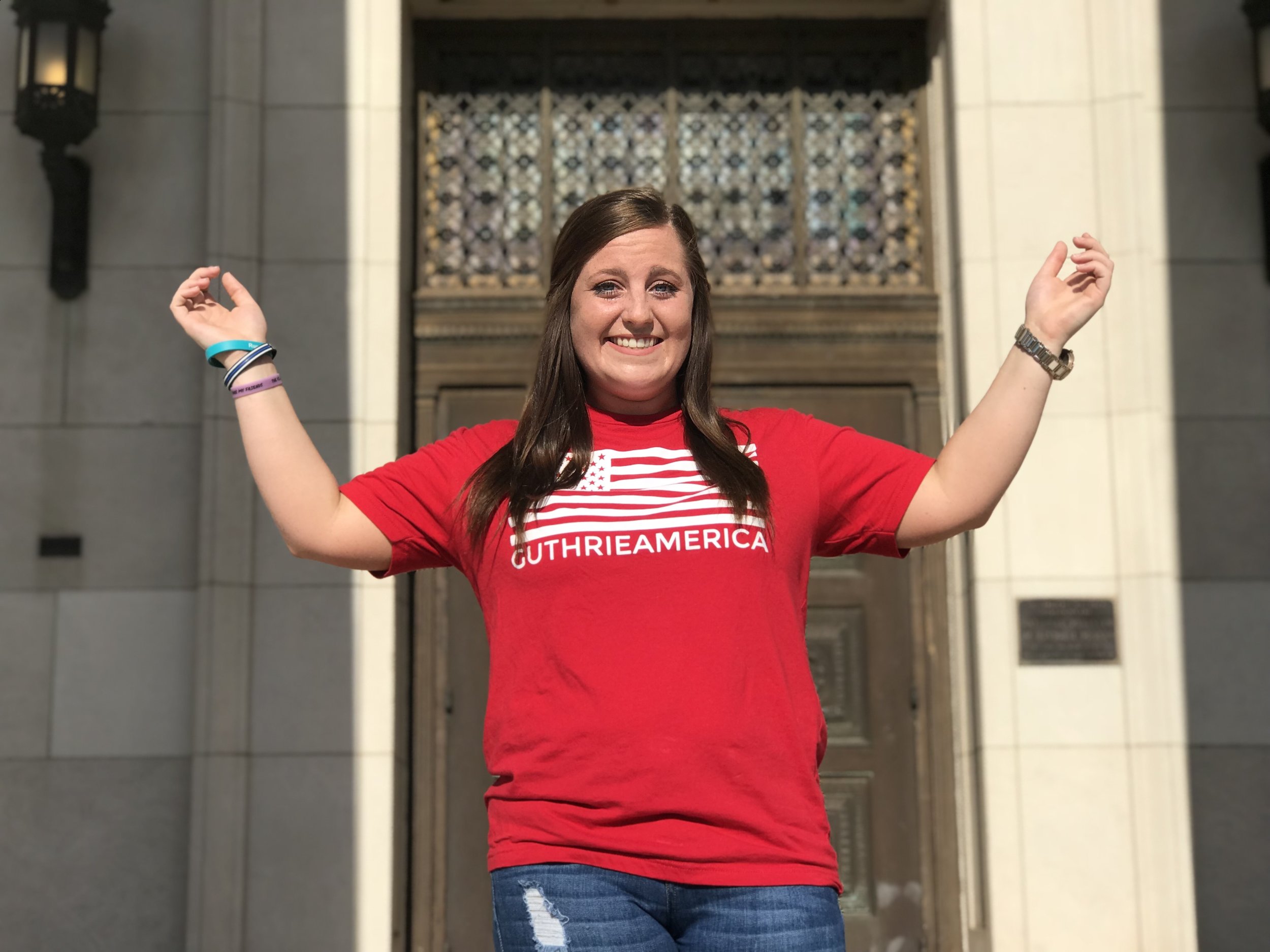 mollie with hands up in guthrie america tee shirt.jpg