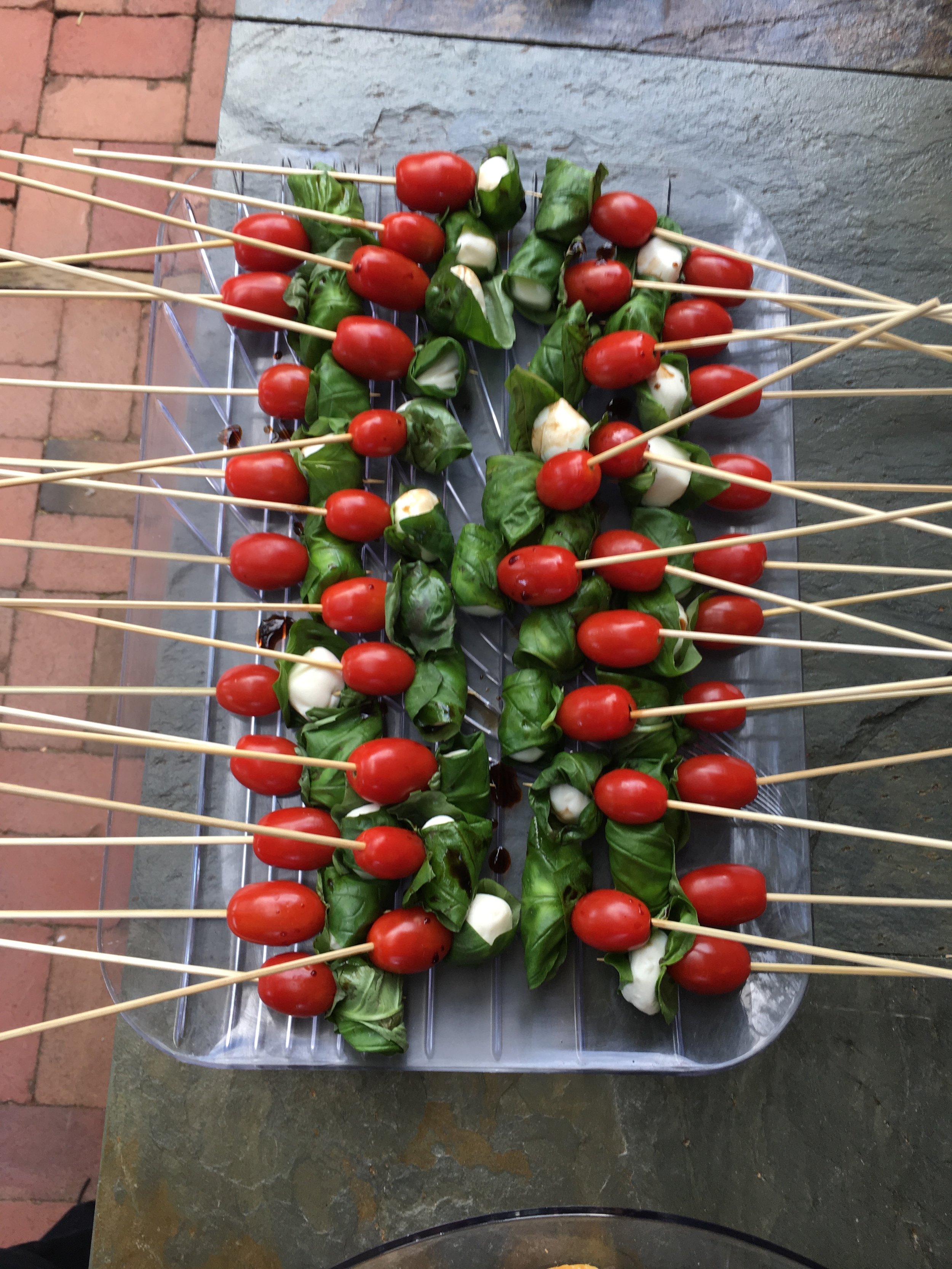 Caprese skewerwith cherry tomato, mozzarella ball, basil, and drizzled of balsamic syrup.