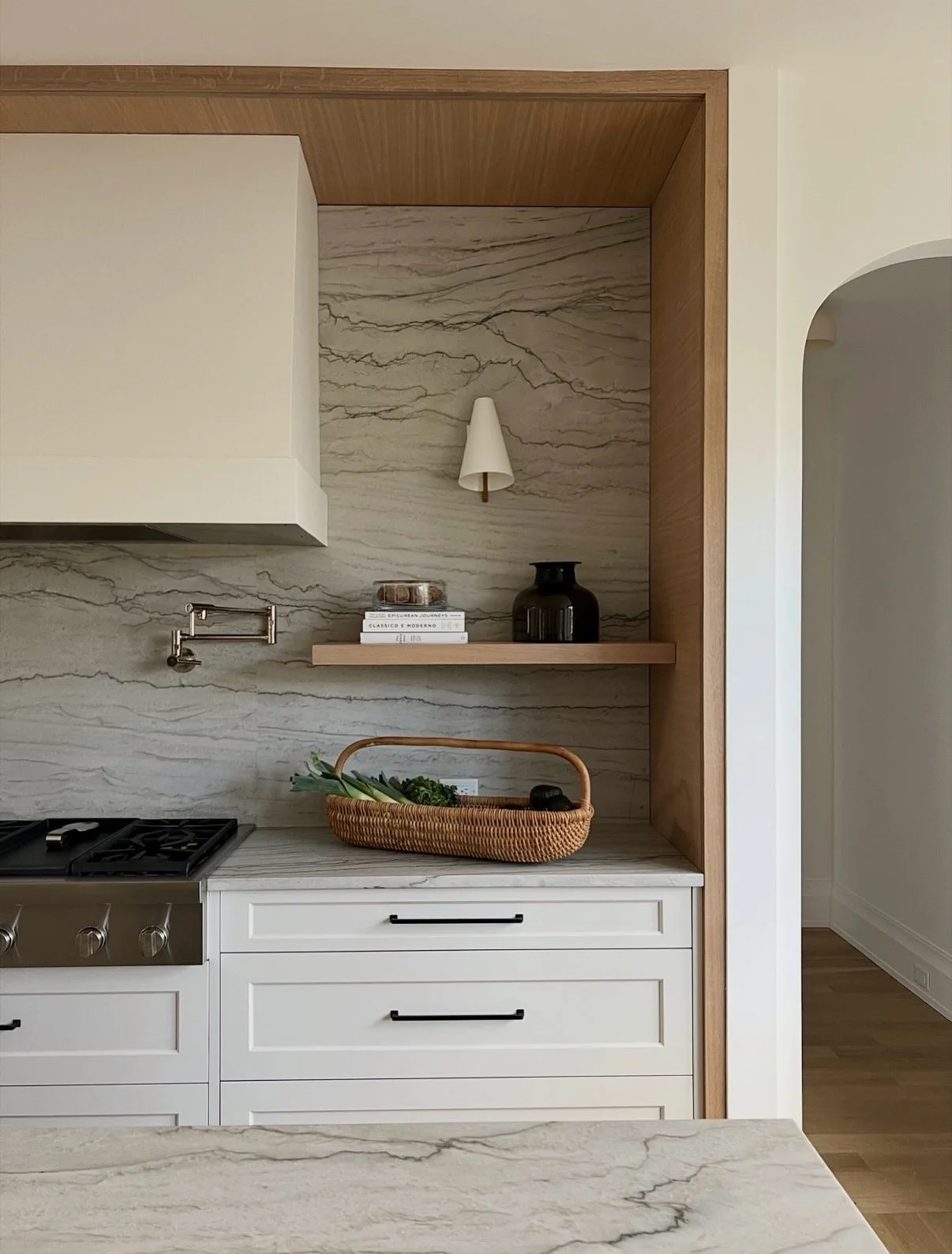 The details in this kitchen never get old -  that stone, that sconce, that shelf. Chef&rsquo;s kiss.
#ShadowlawnWest #MRCxEMD 

Design: @elliemrozdesign 
Construction: @michaelrobertconstruction 
📷: @lauramossphotography 

#kitchendesign #stonebacks