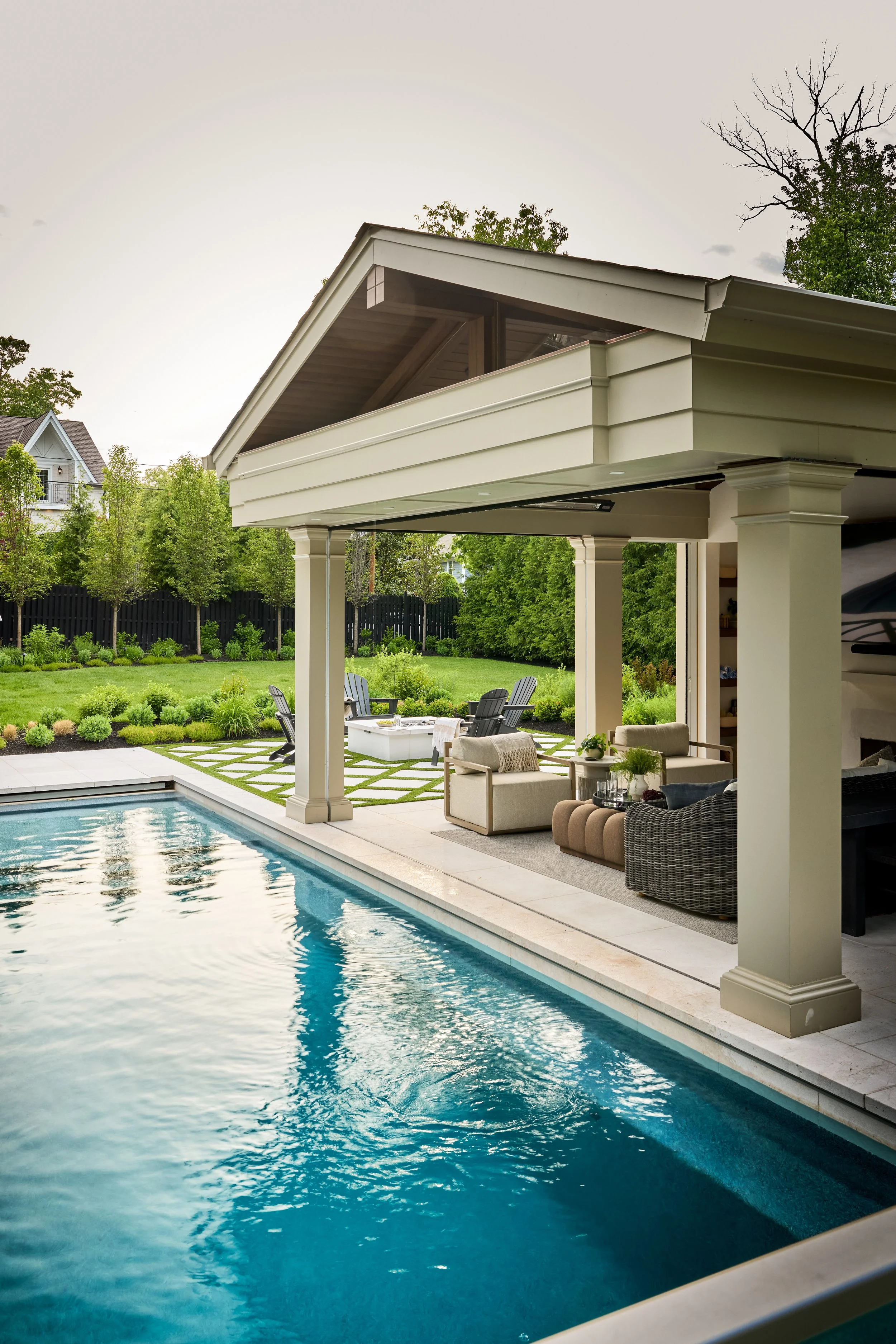 Custom gabled pool pavilion with detailed columns, open-air lounge, integrated lighting and limestone pool surround in NJ.jpg