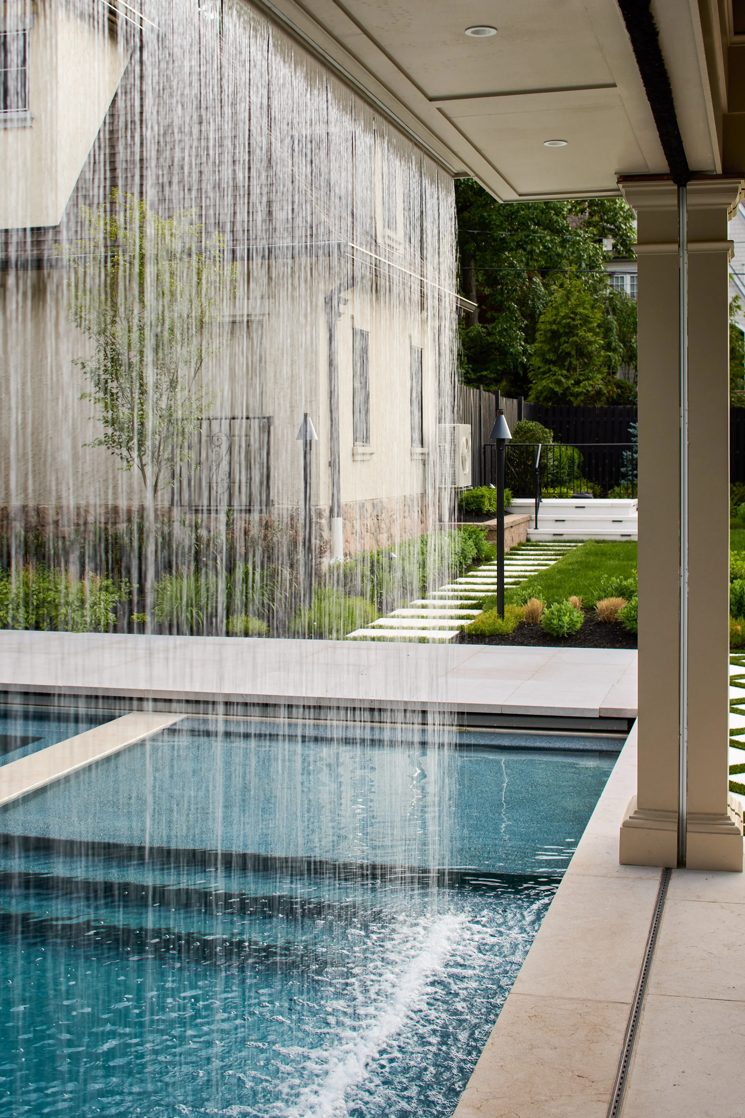 Custom swimming pool with architectural waterfall curtain and covered outdoor living cabana pavillion built by Michael Robert Construction in New Jersey.jpg