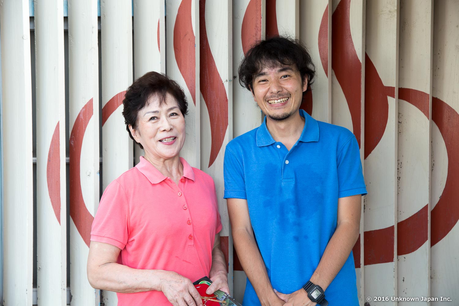 入口の前に描かれている大きな温泉マークの前でオーナーの新堀タエ子さんと撮影