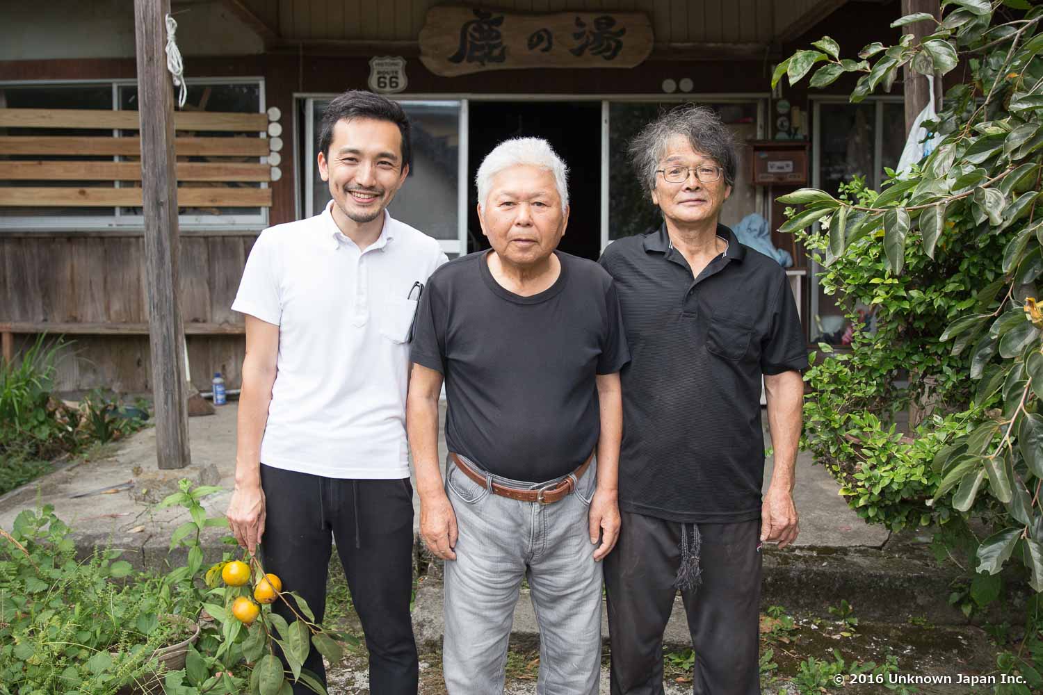 オーナーの柴田信男さん(右)とオーナーの悪友、石原国信さん(中央)と宿入口の前で撮影