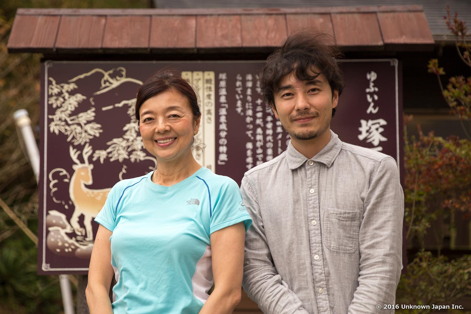 専務の櫻井美得子さんと入口近くの看板の前で撮影