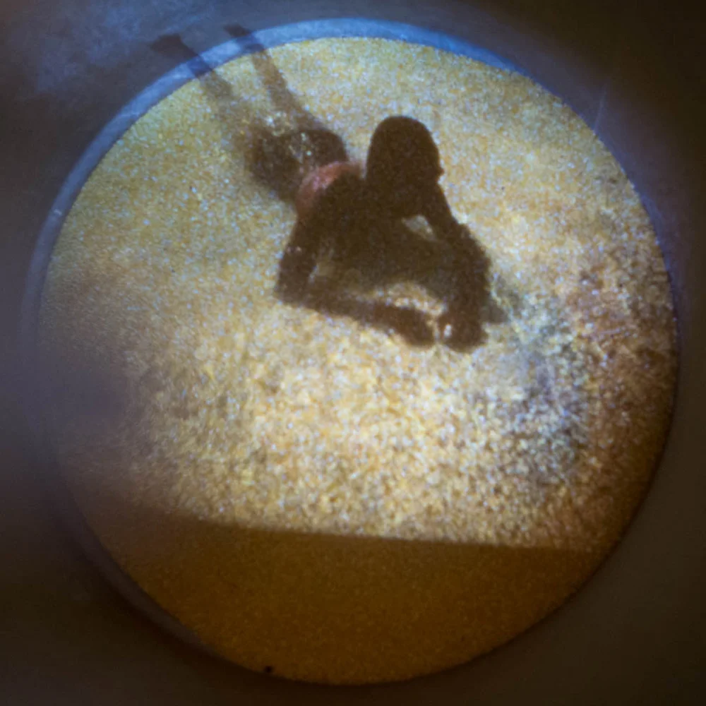 Stills of Video Projection on Cornmeal inside shipping barrel. Duration 1:42