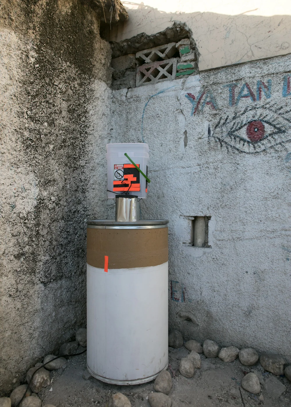 Diorama with Video Projector. Installation View. House paint on Shipping Barrel, Paint Can, Plastic Bucket, Cornmeal