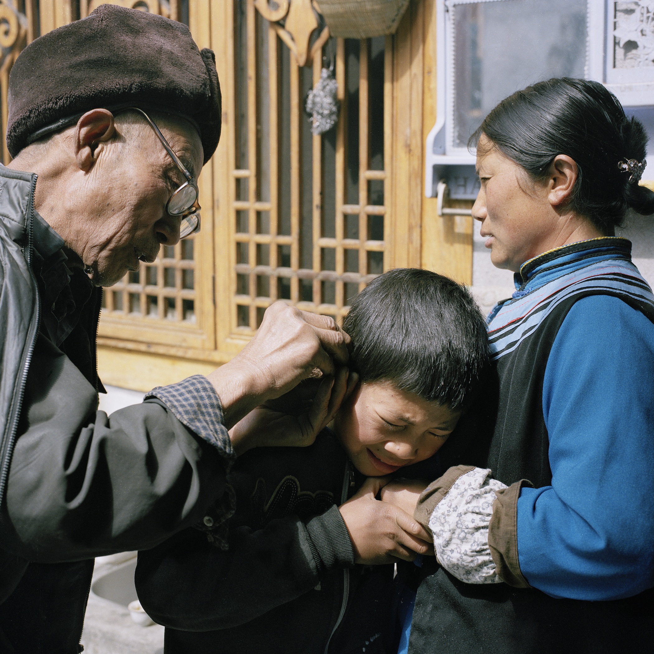 Shaman Burning a Boy's Ear to Drive away Evil Spirits, Radish Village, Sichuan, China, April 2016