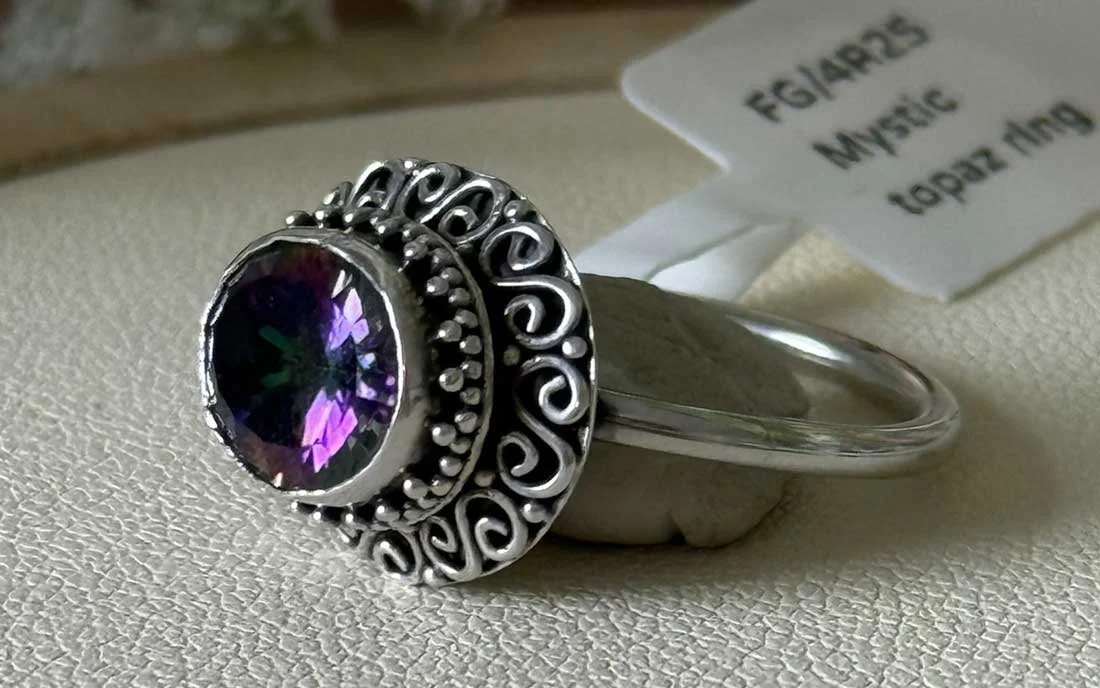 Sterling silver Mystic Topaz ring with iridescent gemstone and ornate scrollwork, handcrafted by artisans in Bali