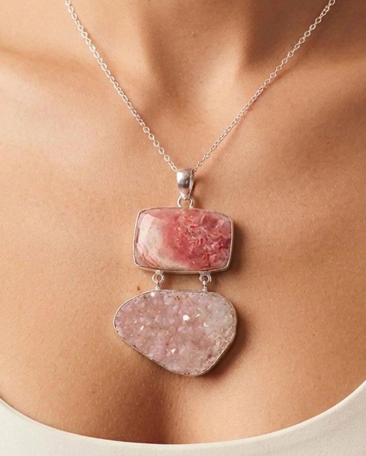 Pink rhodochrosite and druzy pendant worn on a silver chain
