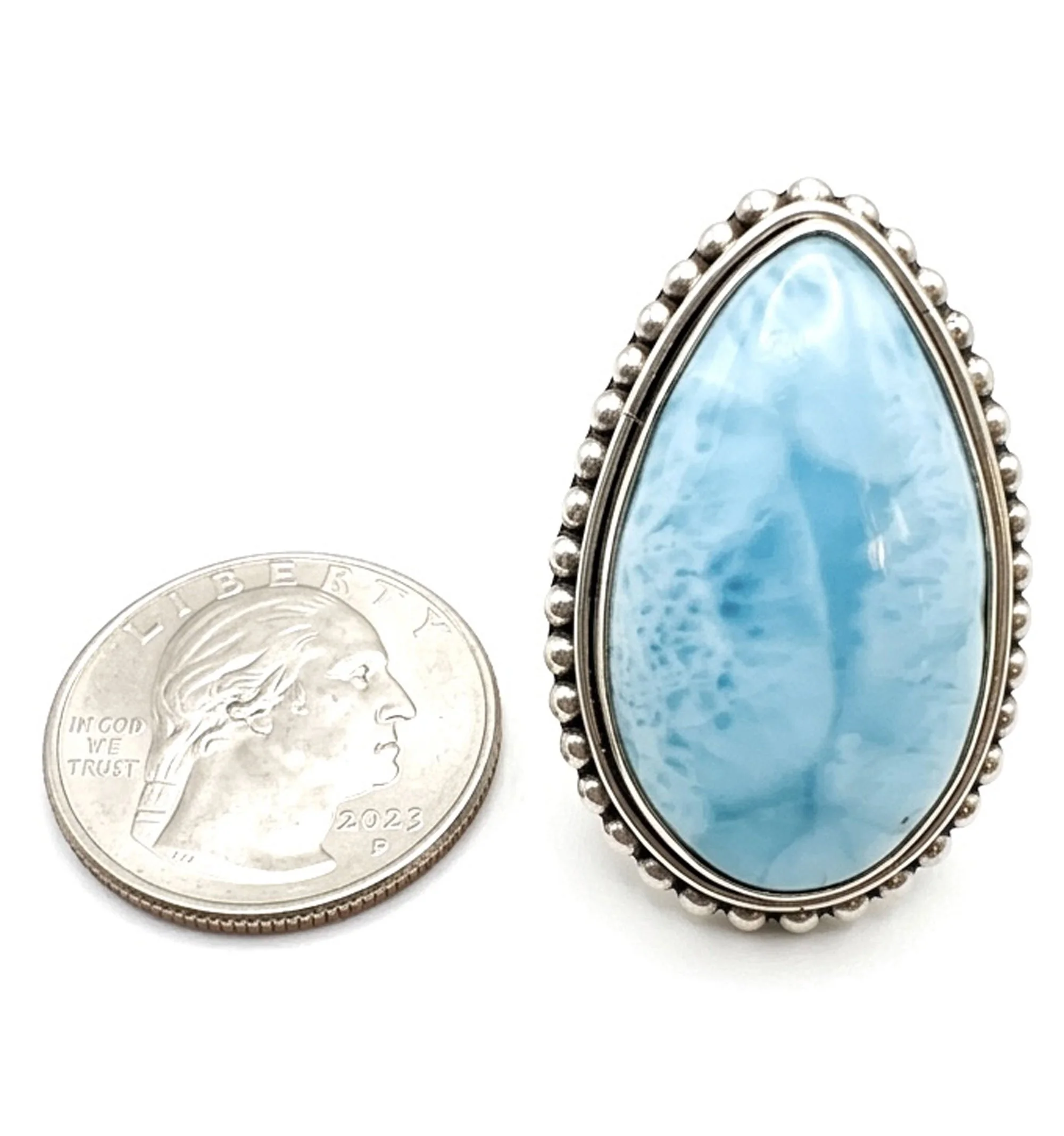Large Larimar teardrop ring next to a coin for size reference
