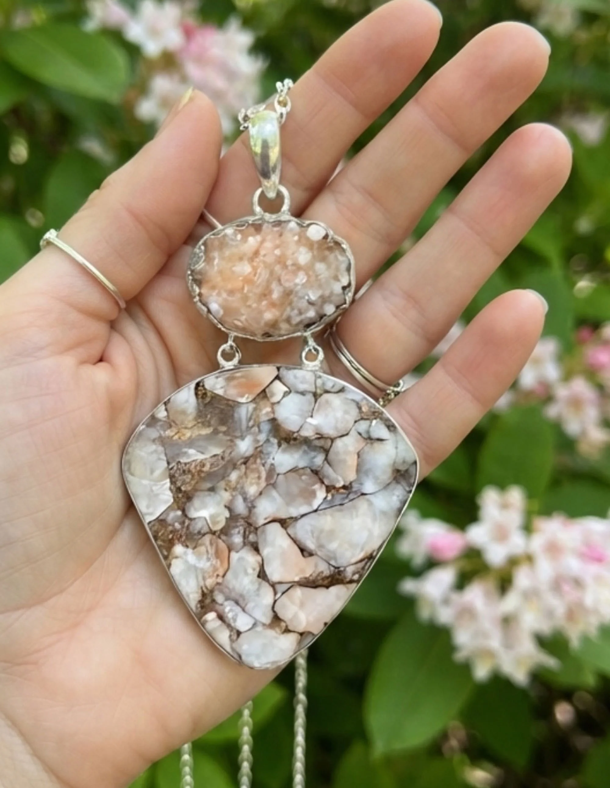 Hand holding one-of-a-kind Calcite sterling silver pendant