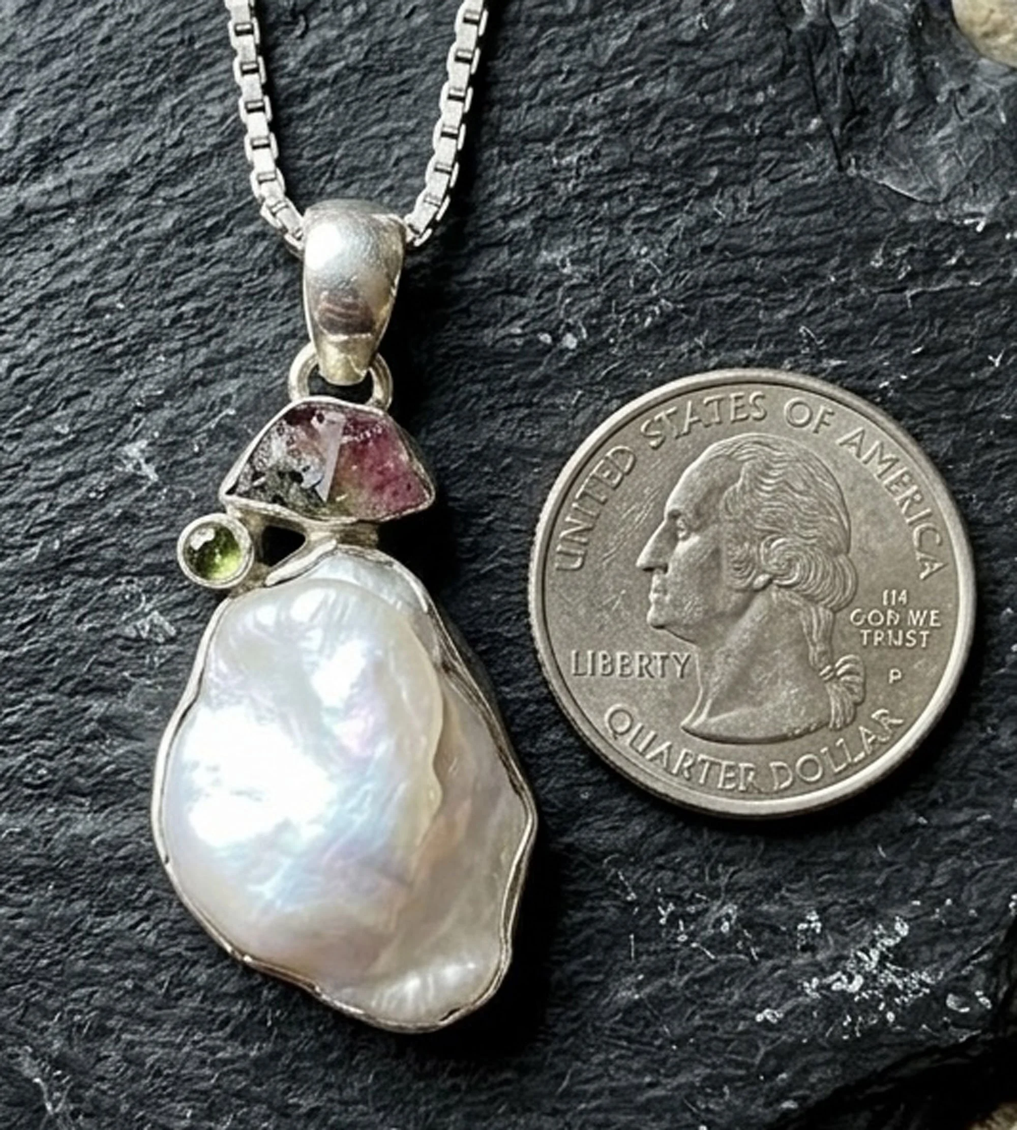 Baroque pearl and tourmaline pendant in sterling silver next to a quarter for size comparison handcrafted artisan gemstone jewelry