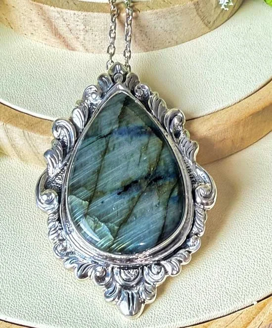 Sterling silver pendant featuring a teardrop-shaped labradorite gemstone with iridescent blue and green flashes, handmade by artisans in Bali.