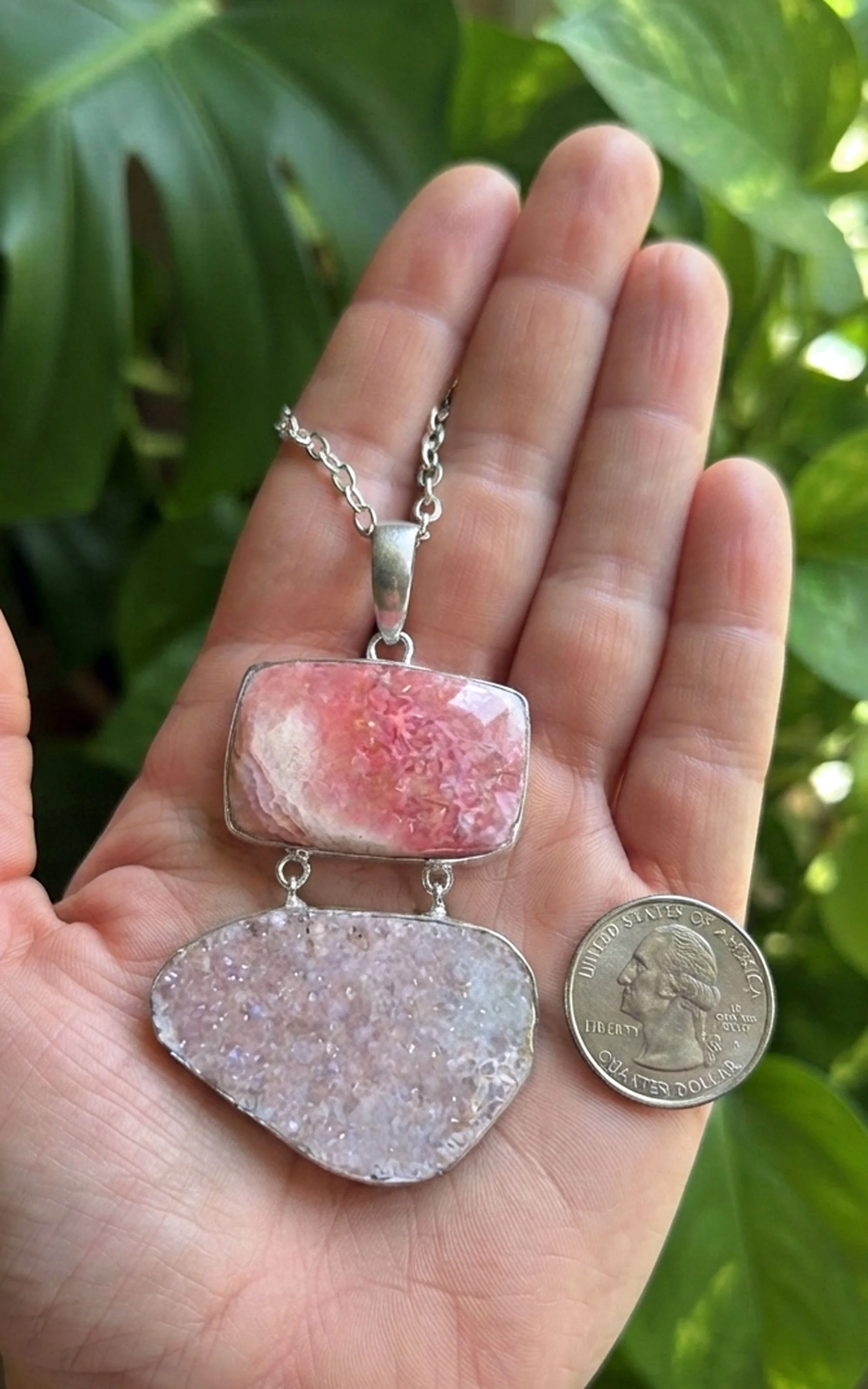 Rhodochrosite and sparkling druzy sterling silver pendant held in hand for scale