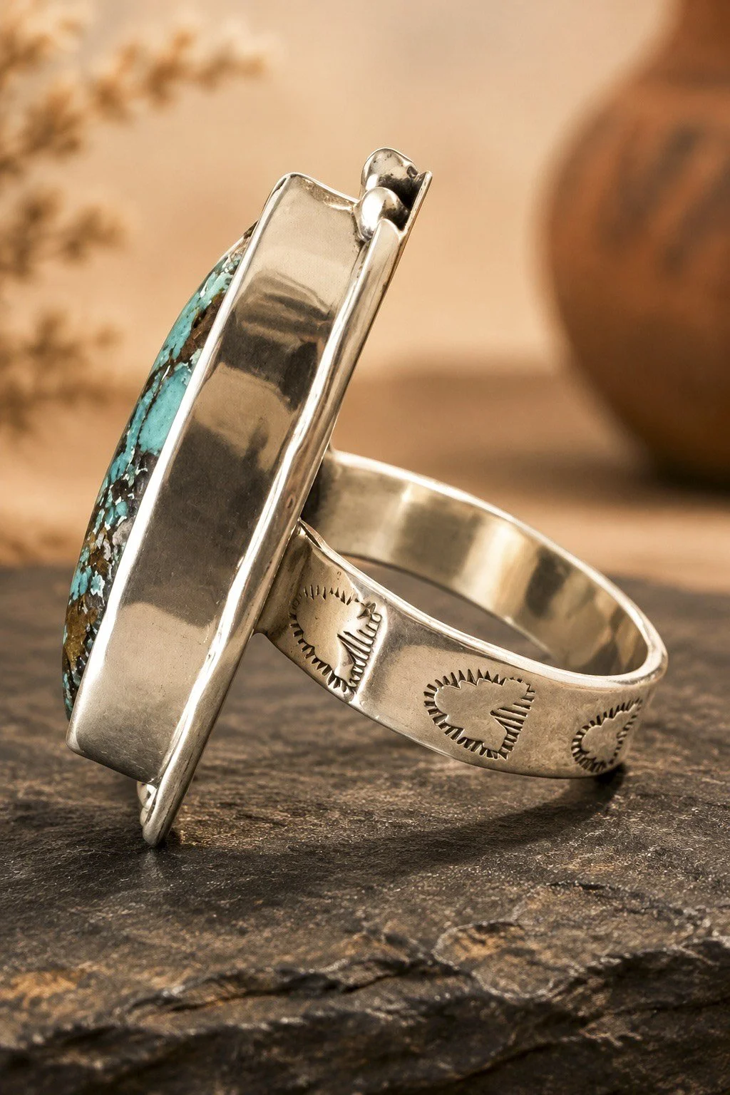 Side view of turquoise sterling silver ring showing decorative stamped silver band