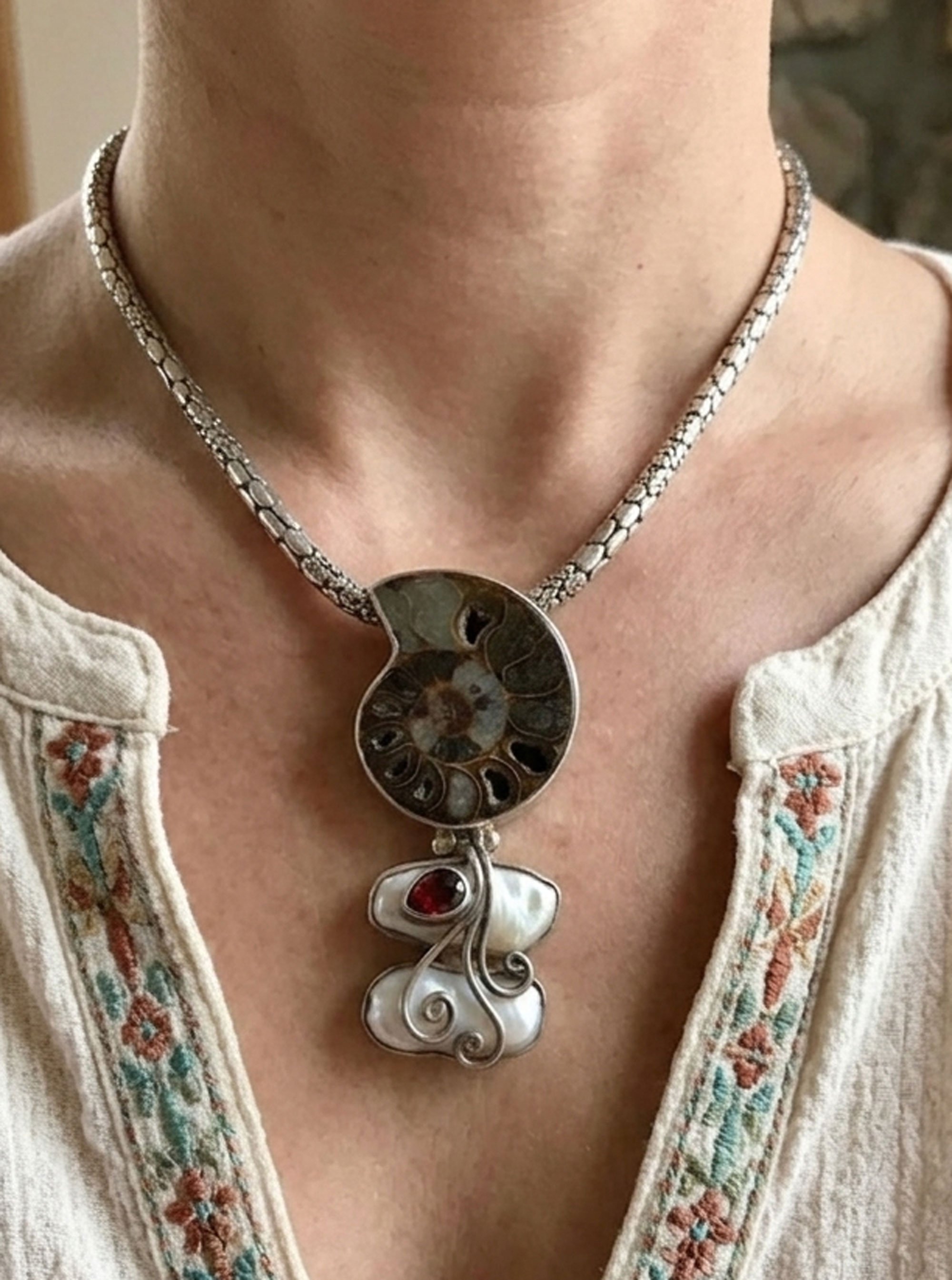 Ammonite fossil pendant with pearl and garnet on model sterling silver artisan jewelry
