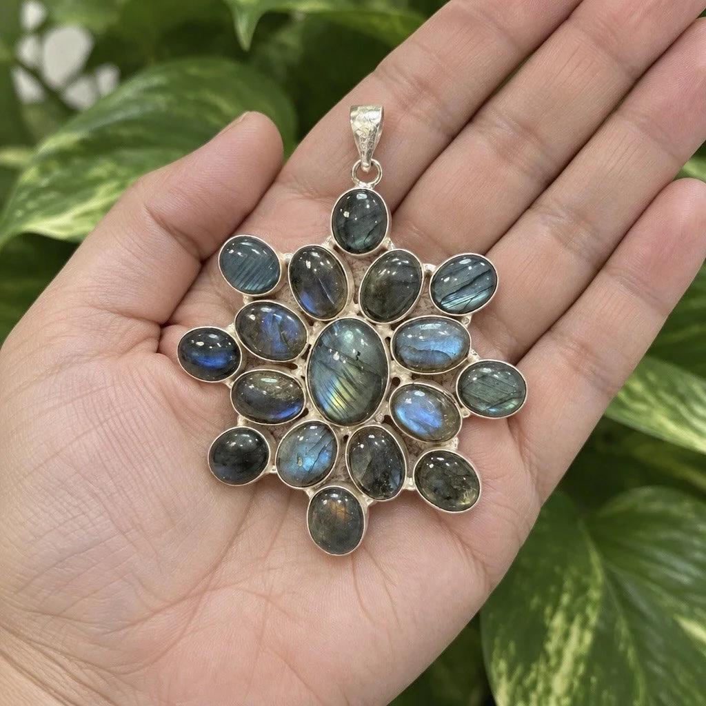 Large multi-stone labradorite statement pendant shown in hand for scale