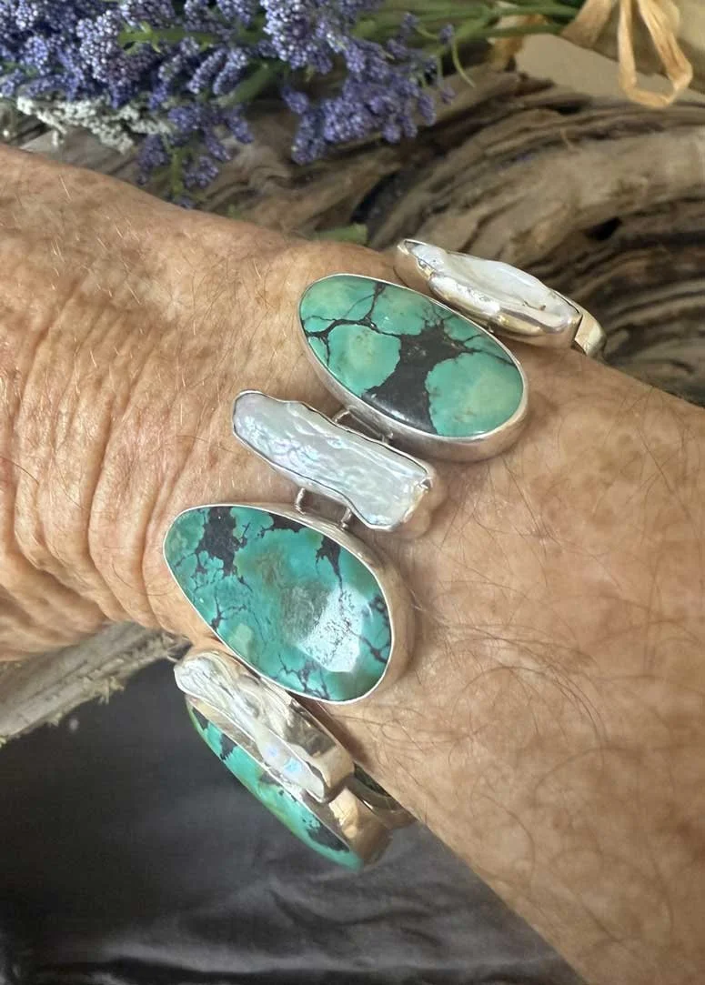 Handmade sterling silver turquoise and pearl adjustable bracelet featuring natural gemstones and artisan design. Boho chic jewelry crafted with elegance and meaning.